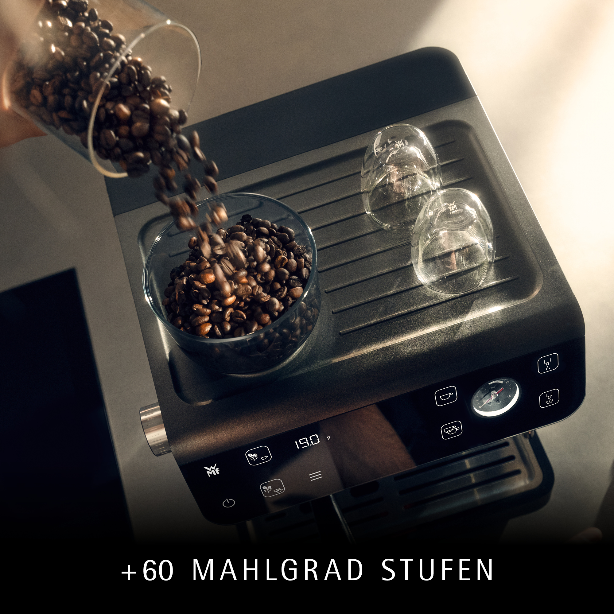 Kaffeebohnen werden in eine Schale über einer Espressomaschine gegossen.
