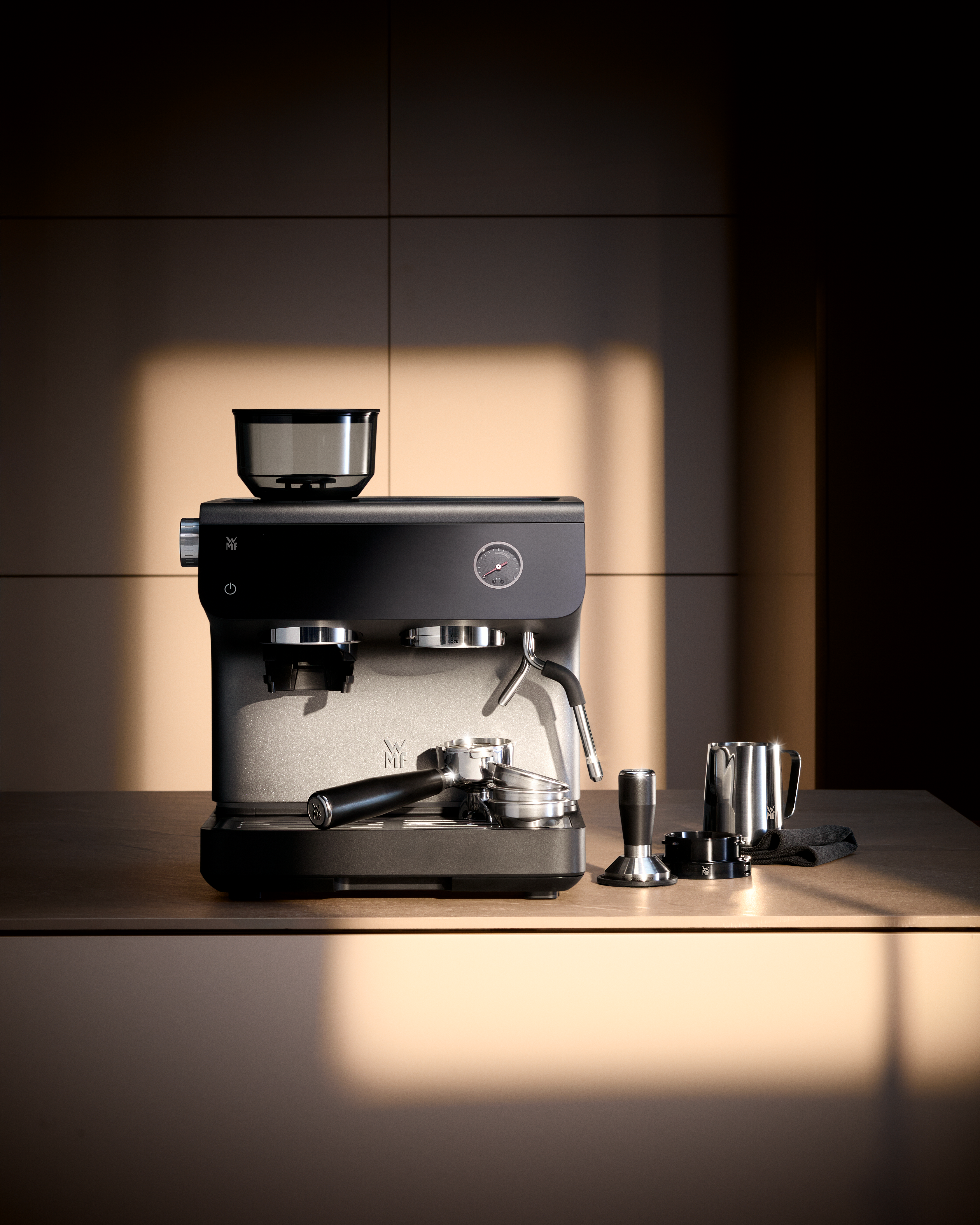 Eine Espressomaschine mit Zubehör steht auf einer Arbeitsplatte.