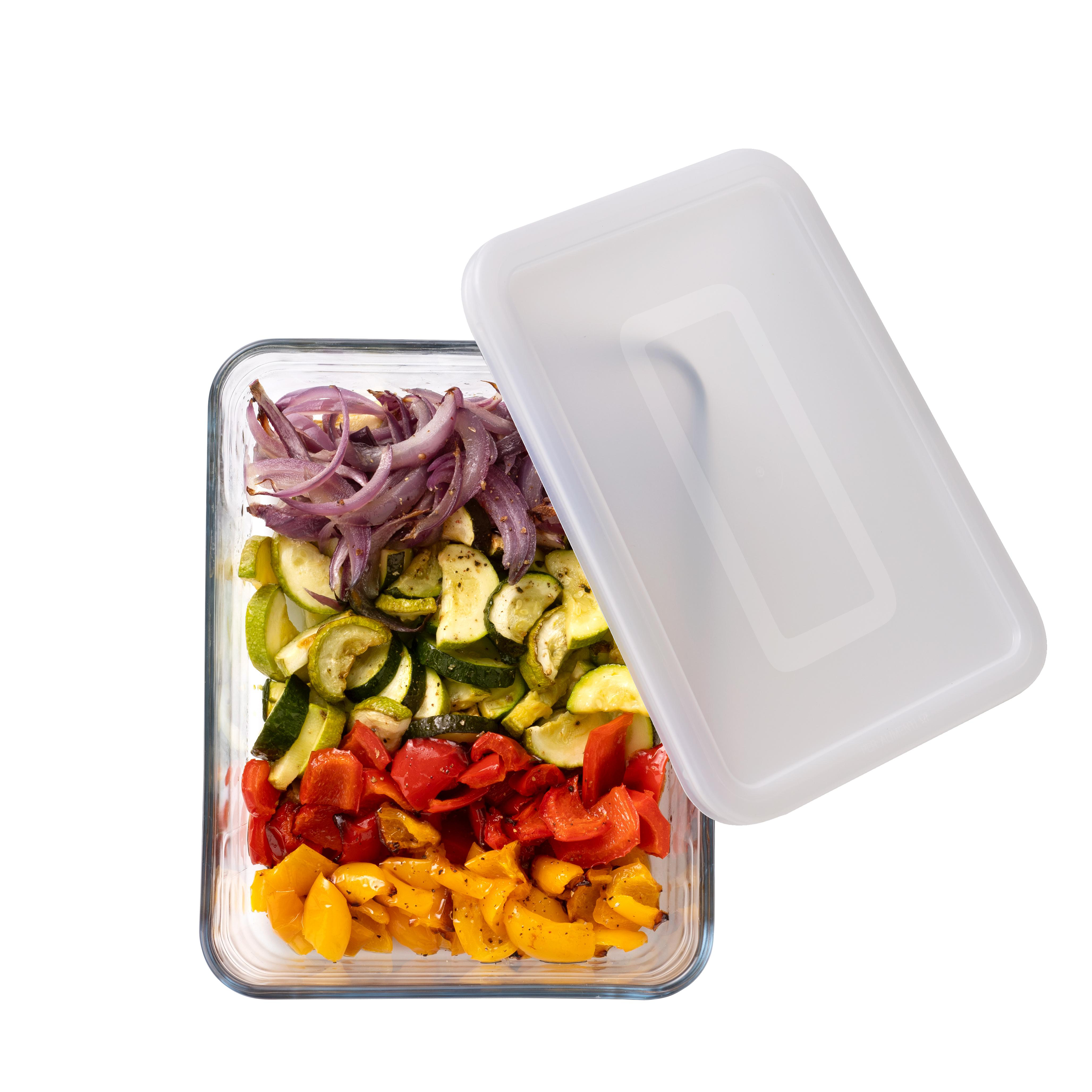 Gegrilltes Gemüse in einer Glasbox mit offenem Deckel: Zwiebeln, Zucchini, Paprika.