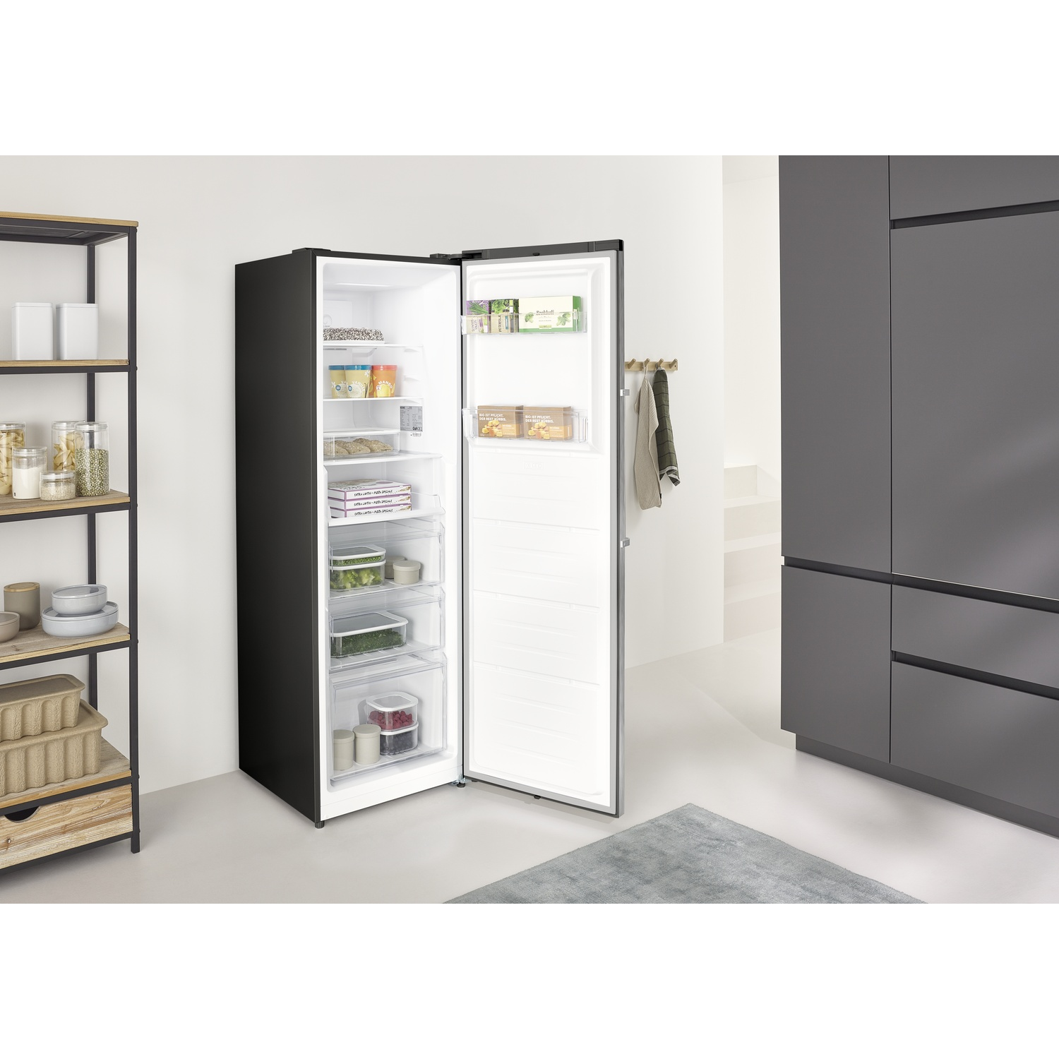 An open black refrigerator with food items and drawers inside.
