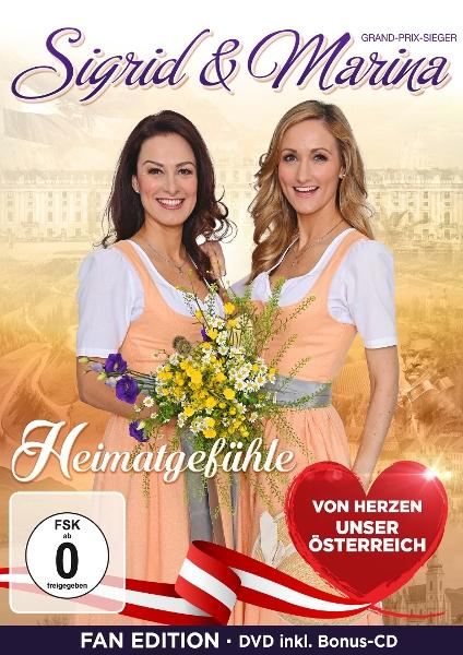 Zwei Frauen in Tracht halten einen Blumenstrauß, "Sigrid & Marina Heimatgefühle" steht darüber.