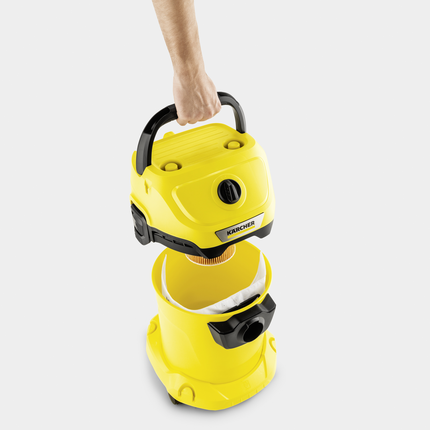 Yellow Karcher vacuum cleaner held by hand, filter visible.