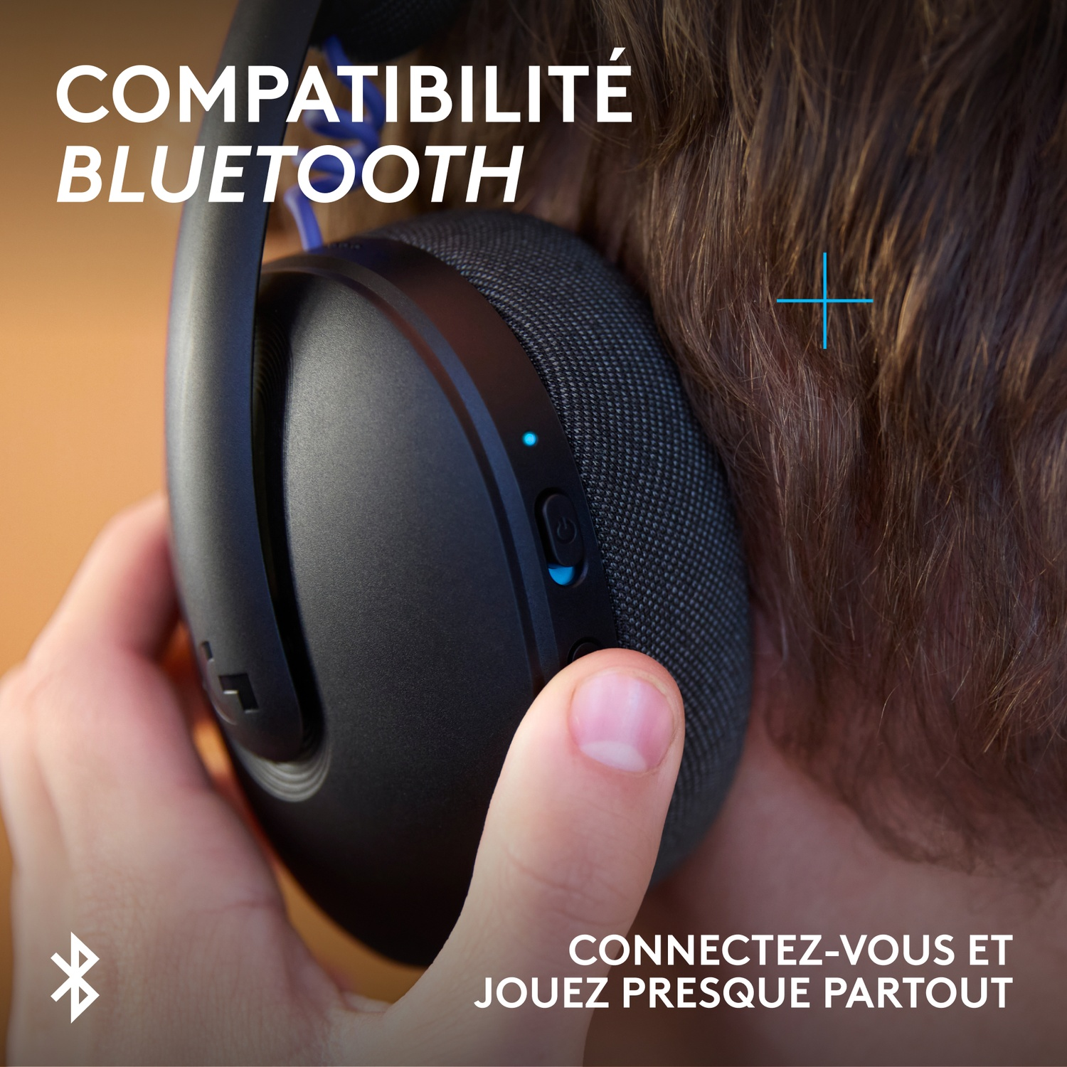 Close-up of headphones held by a hand, with text overlay.