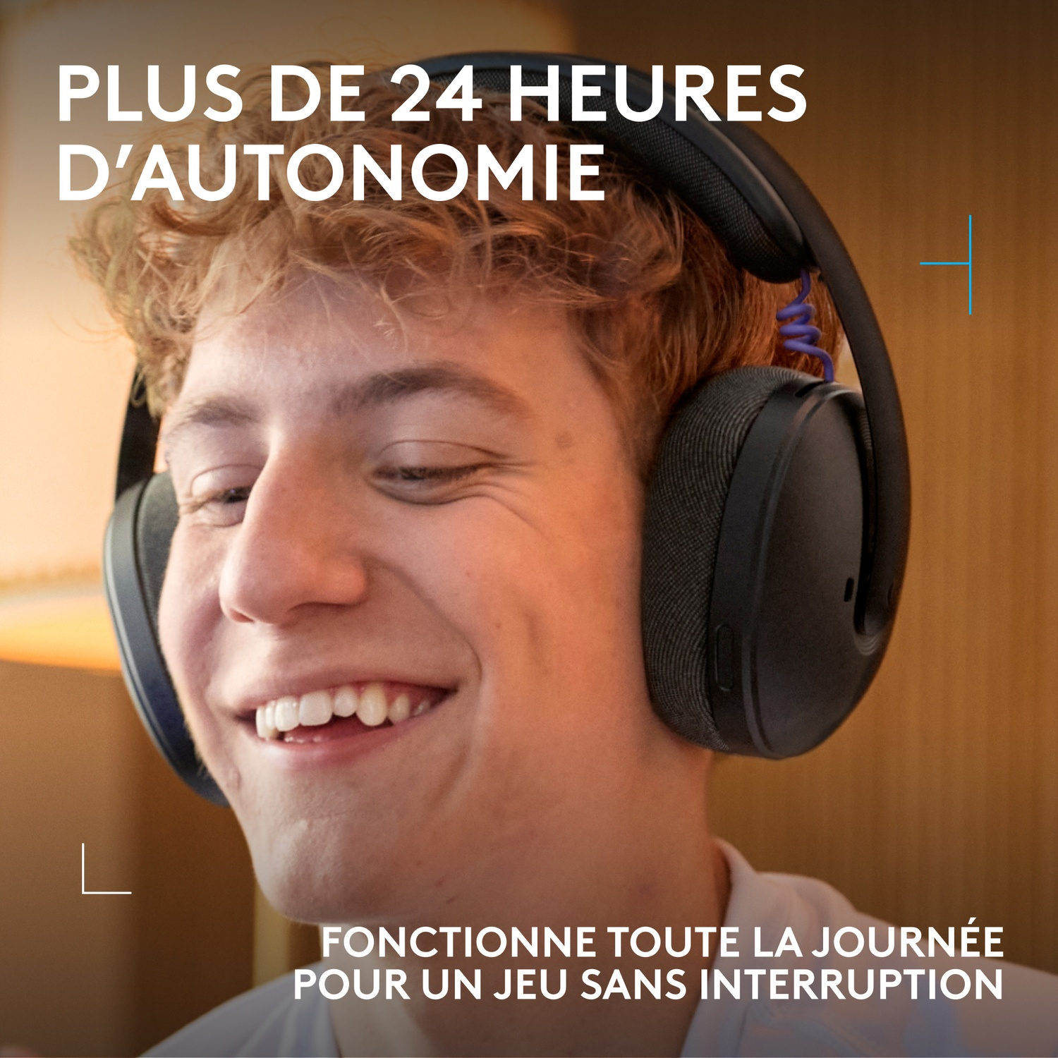 Young man wearing headphones is laughing. Text: Over 24 hours of battery life.