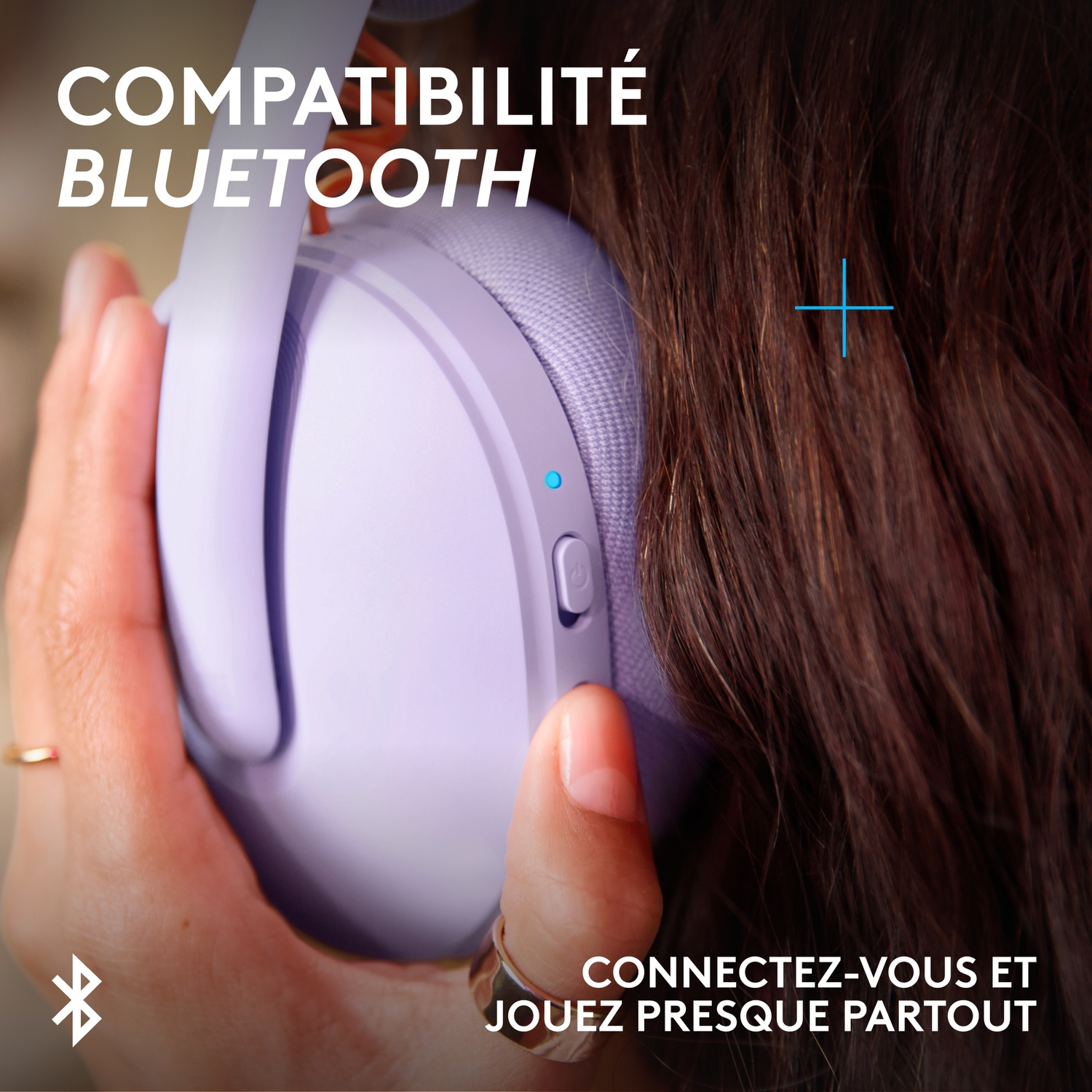 A hand holds a purple headphone. Text: Bluetooth compatibility.