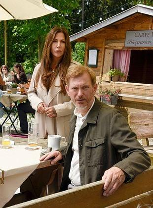 Ein Mann mit Bart und eine Frau stehen vor einem Biergartenhäuschen.