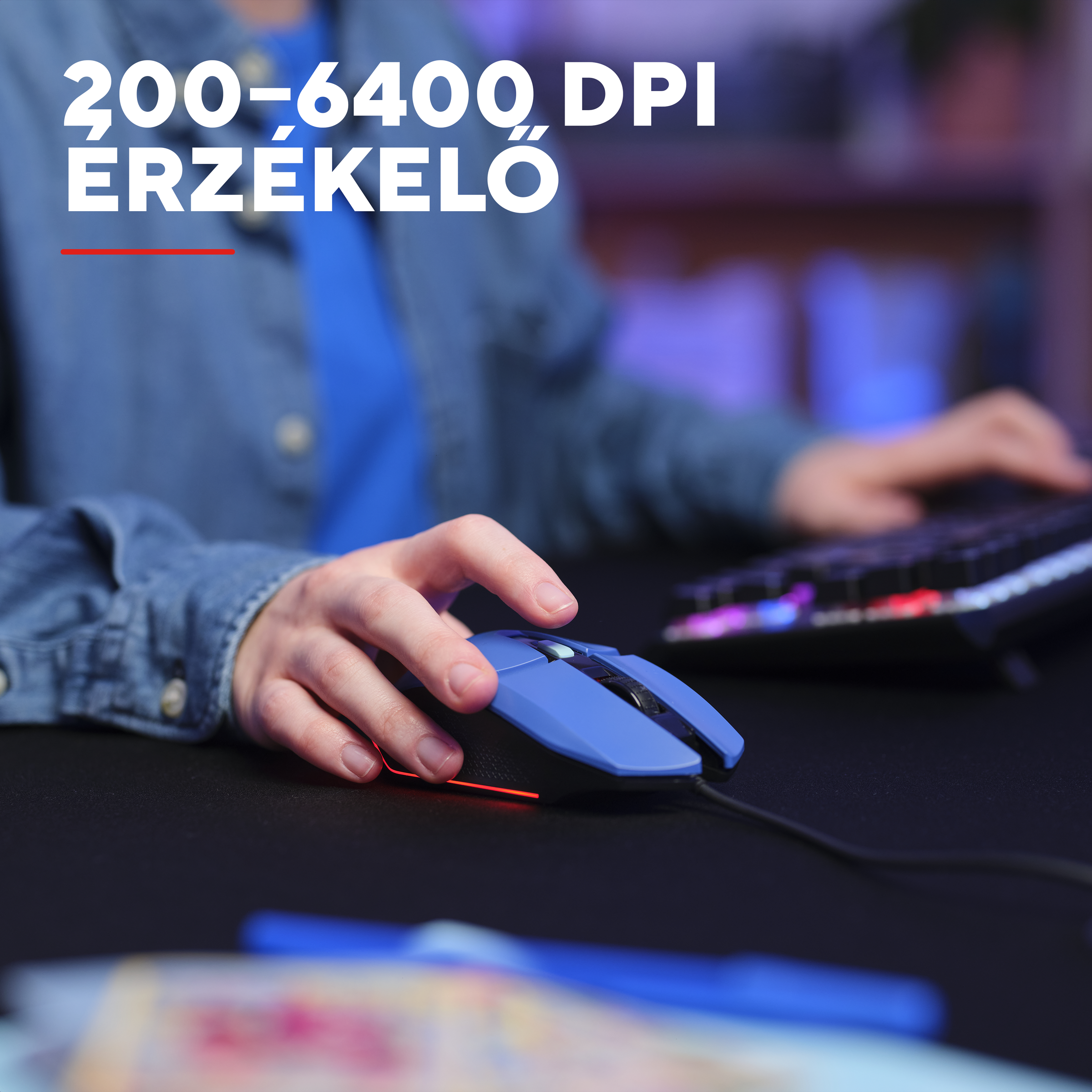 Egy kéz kék gamer egeret használ piros világítással fekete asztalon.