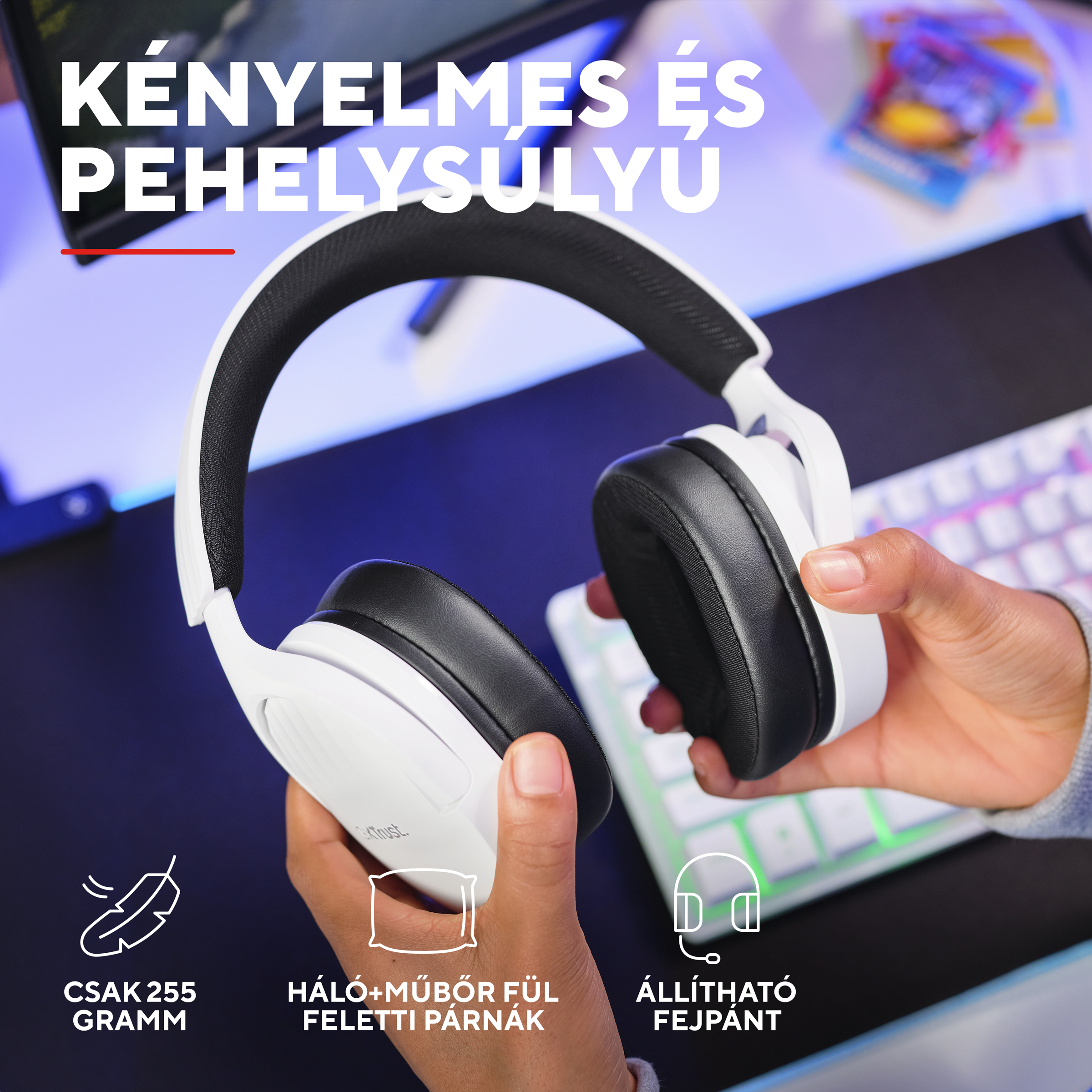Fehér fejhallgató fekete fülpárnákkal kézben, billentyűzet a háttérben.