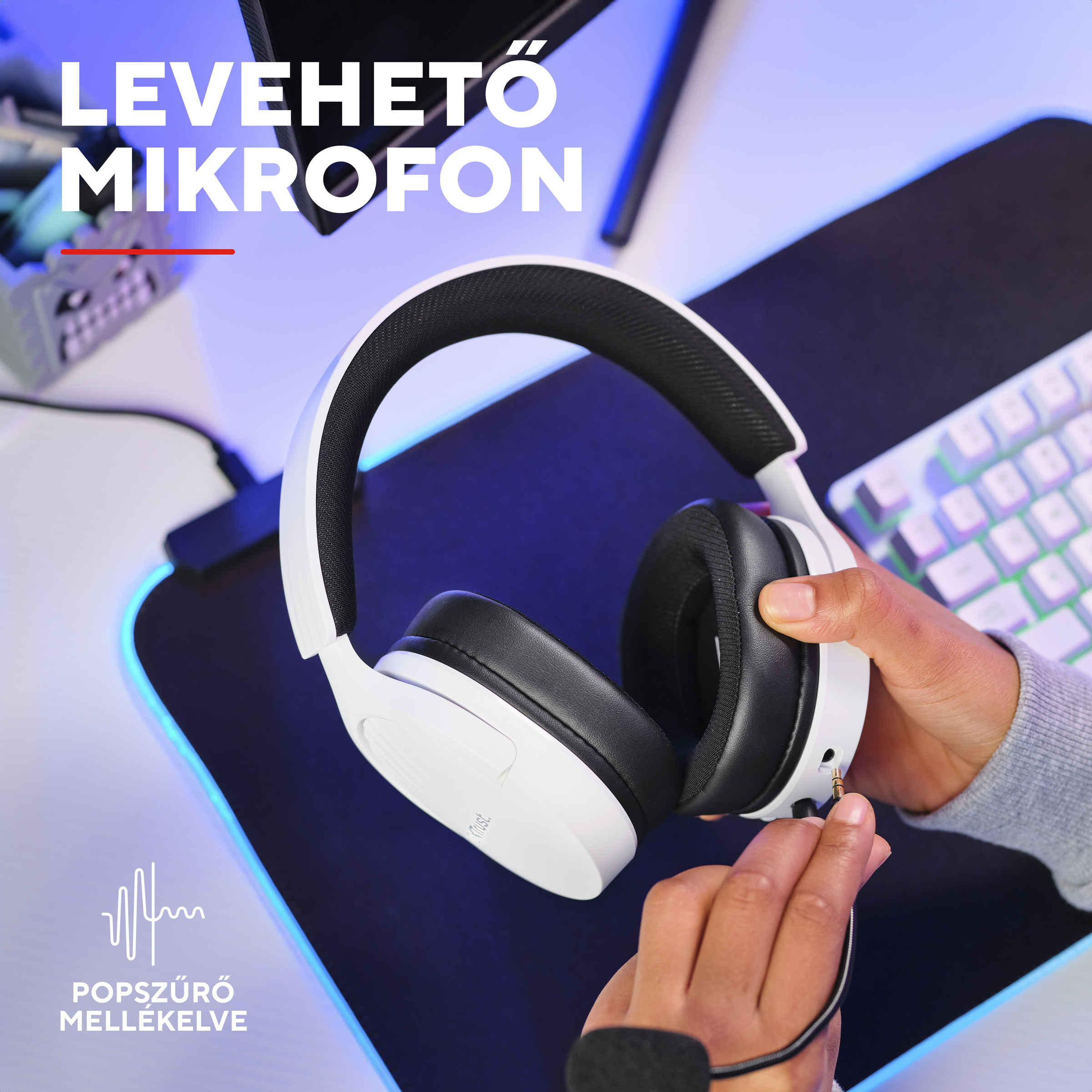 Egy kéz levehető mikrofont dug be fehér fejhallgatóba. Billentyűzet a háttérben.