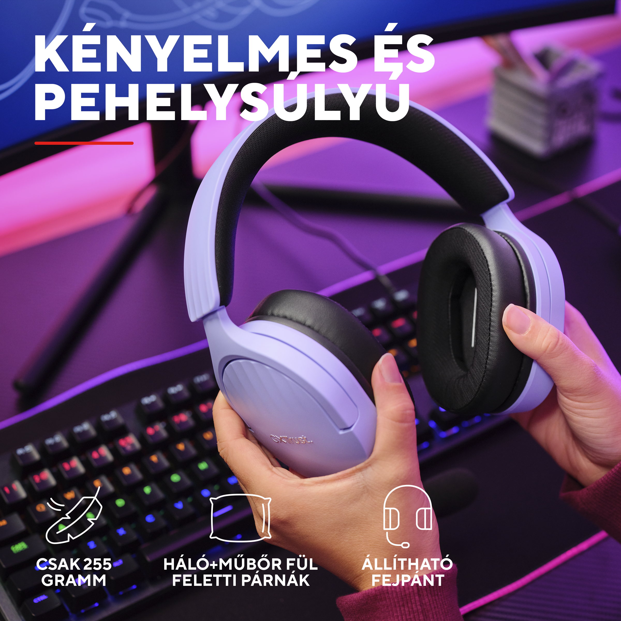 Kezek egy lila fülhallgatót tartanak RGB háttérvilágítású billentyűzet felett.