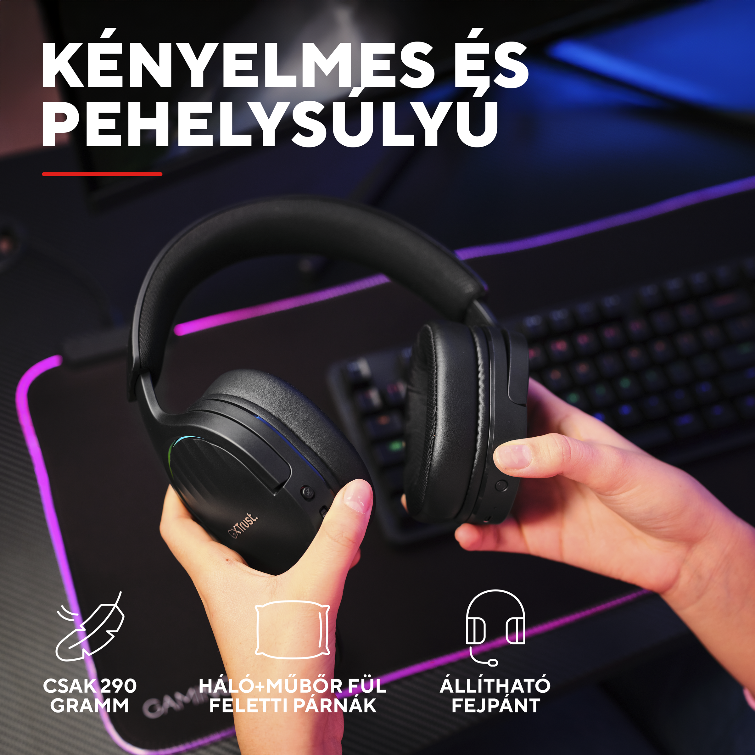 Fekete, RGB-világítású fülhallgató, melyet kezek tartanak, egy billentyűzet előtt.