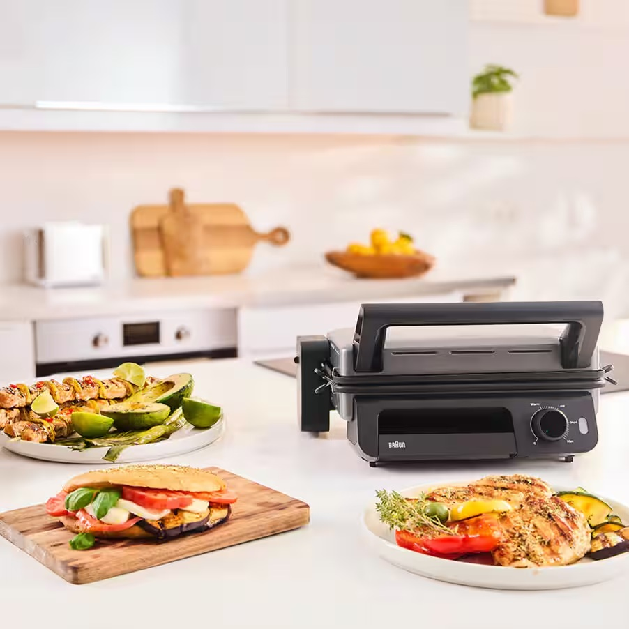 Grill z grillowanymi potrawami i kanapką na blacie kuchennym.