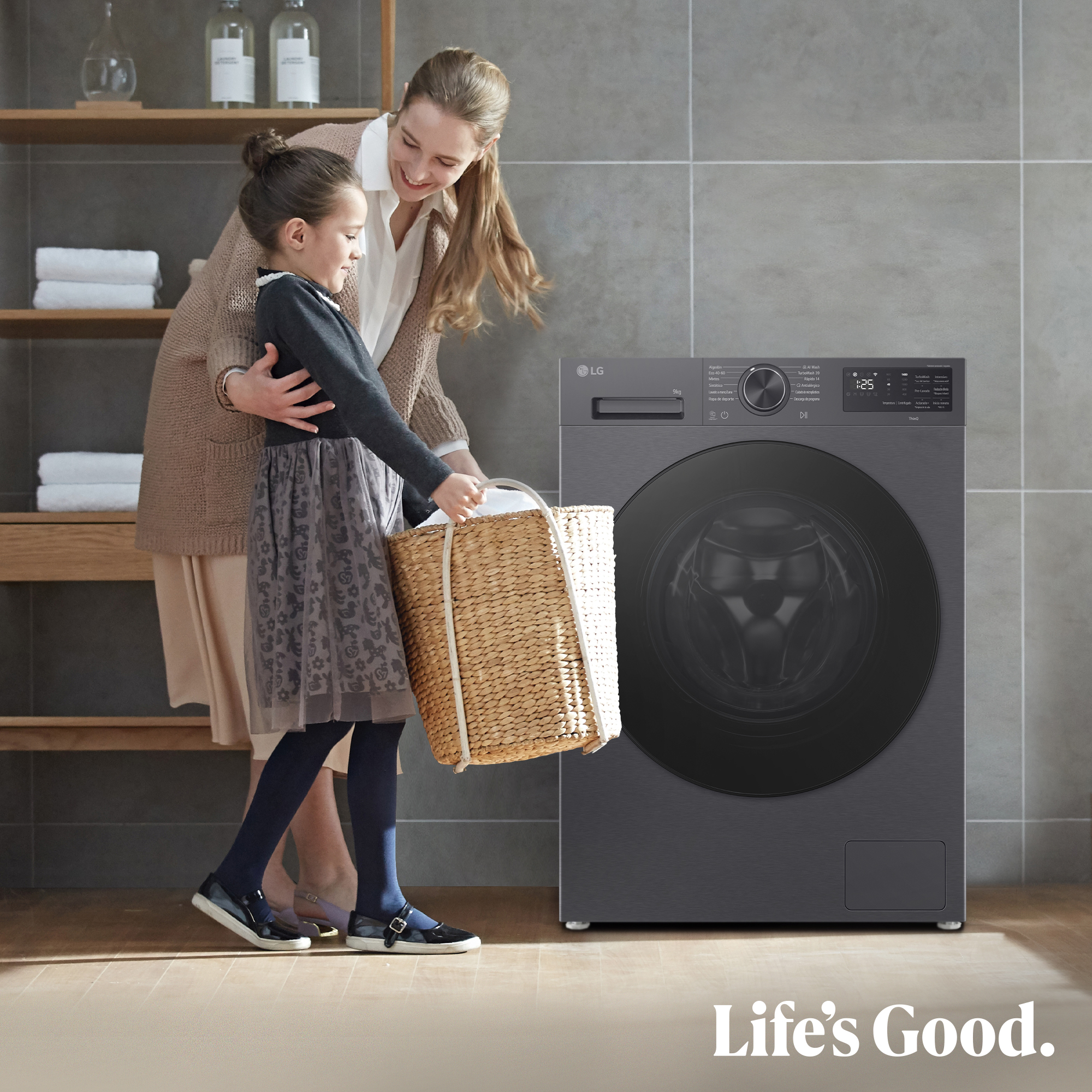 Madre e hija con cesta de ropa junto a una lavadora LG en un baño.