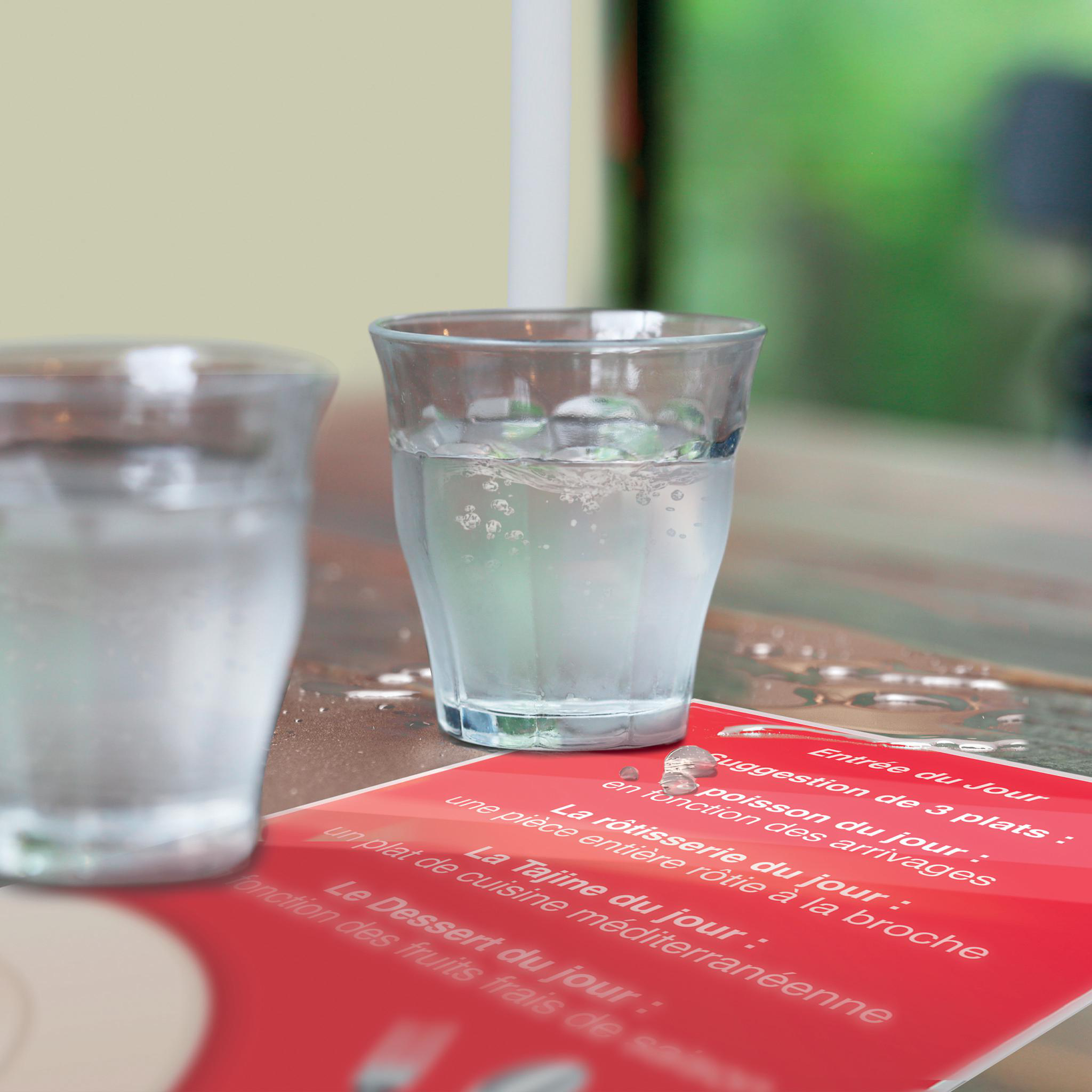 Zwei Gläser Wasser auf einem Tisch mit einer Speisekarte mit französischen Gerichten.