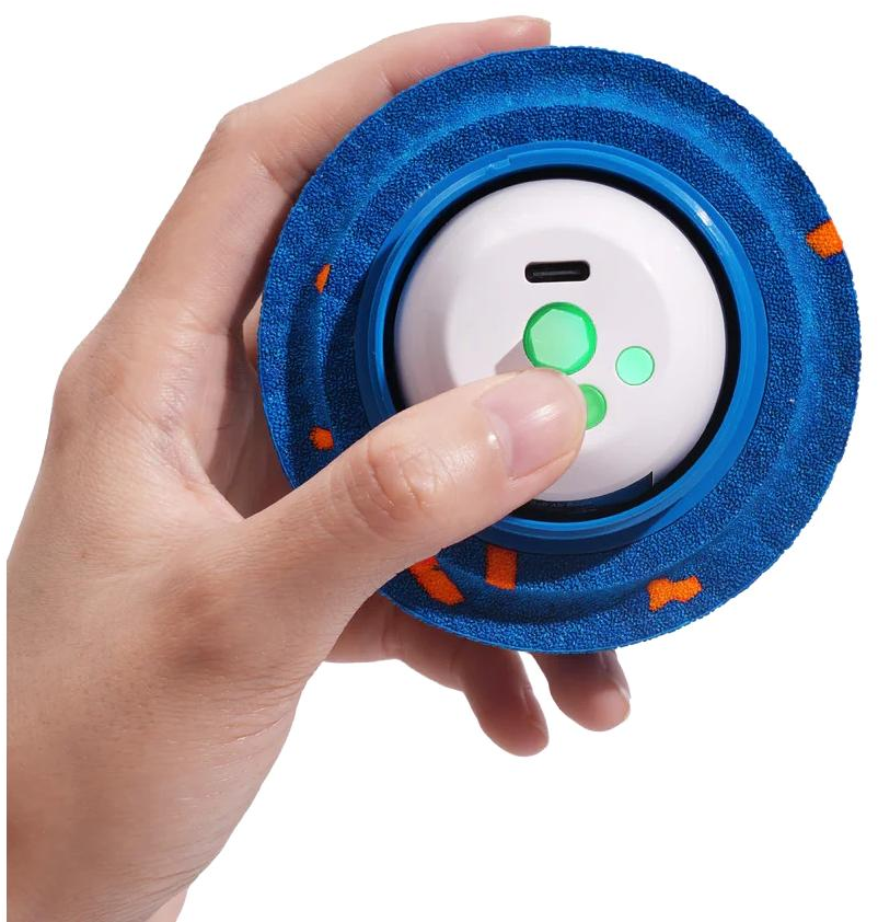 Una mano tiene un oggetto circolare blu con macchie arancioni e centro bianco.