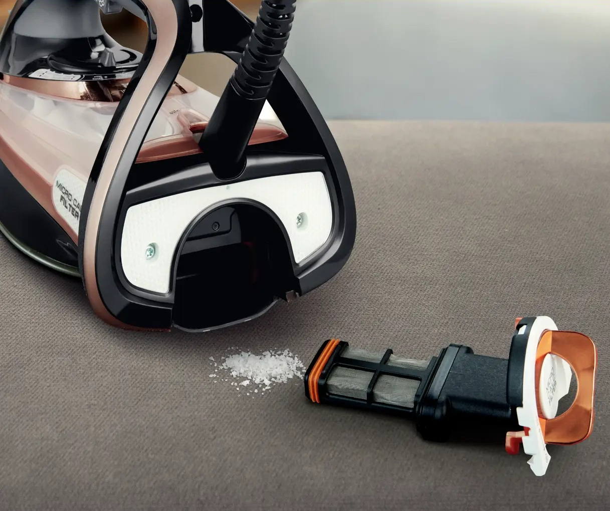 Żelazko parowe z wyjętym filtrem i trochę kurzu.