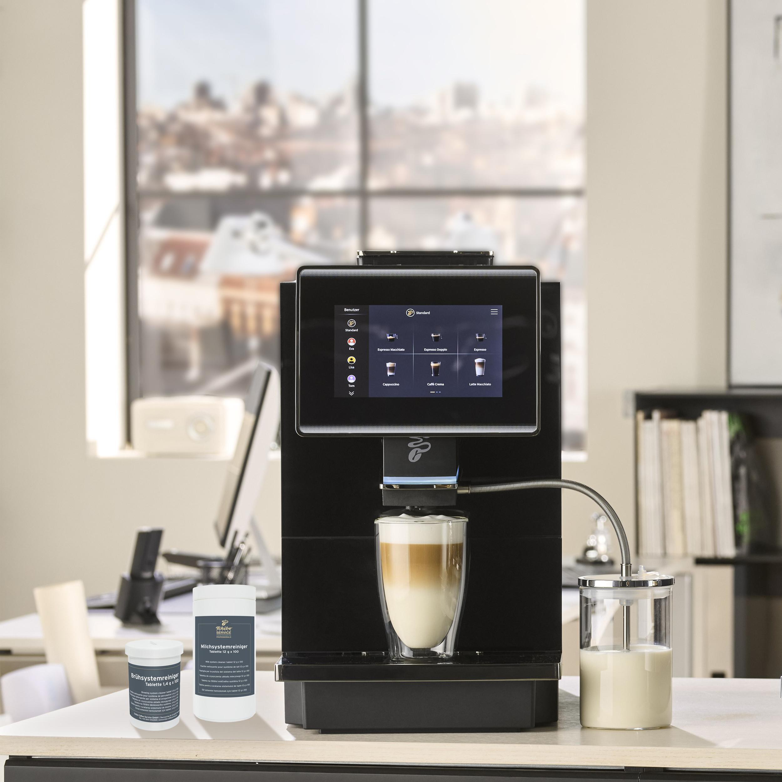 Eine schwarze Kaffeemaschine mit Touchscreen, die einen Latte Macchiato zubereitet.
