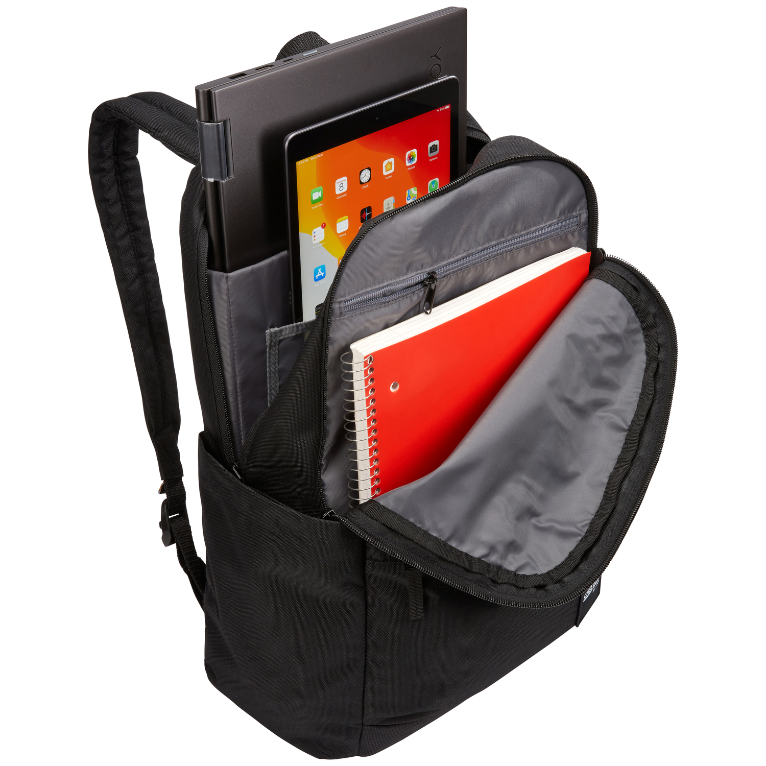 Sac à dos noir avec ordinateur portable, tablette et carnet rouge à l'intérieur.