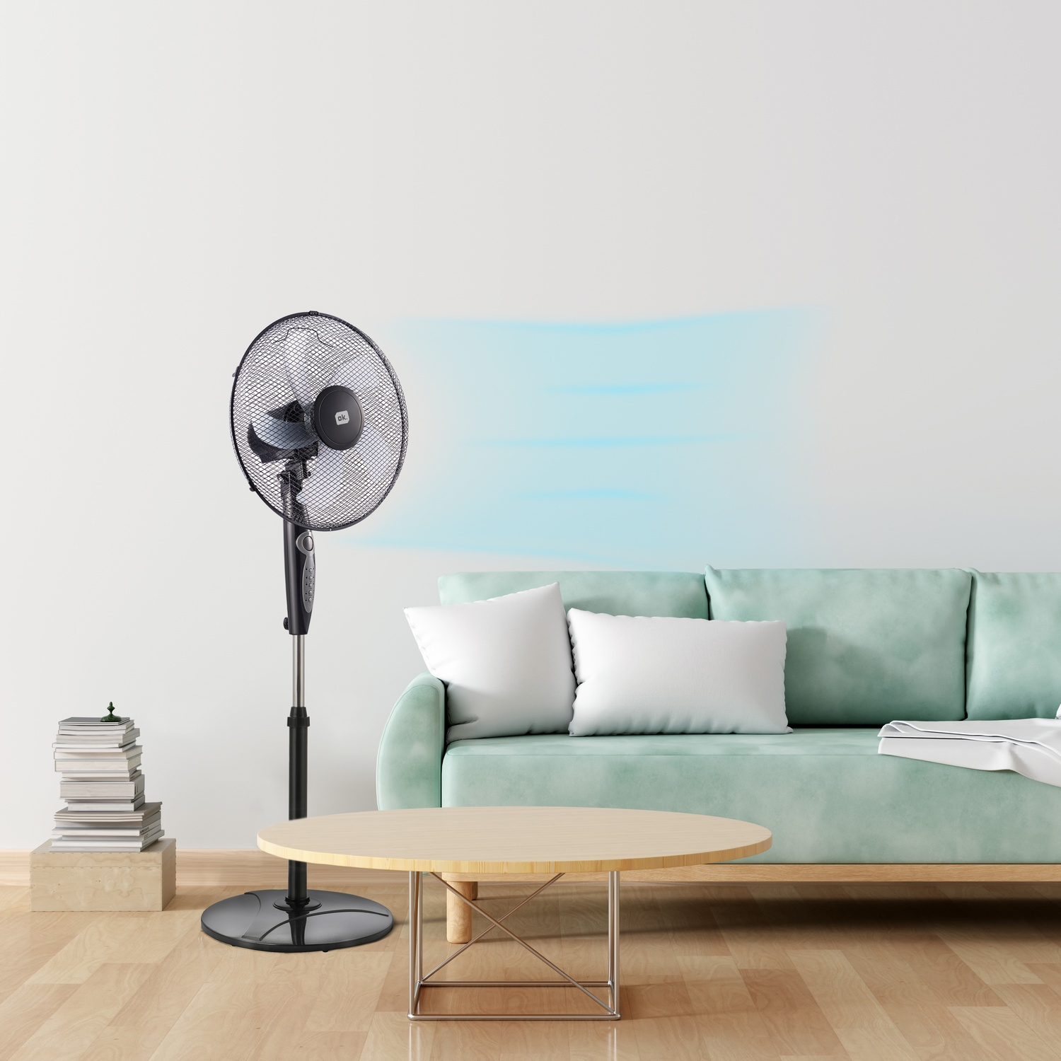 Un ventilatore nero da terra soffia aria blu su un divano verde menta.