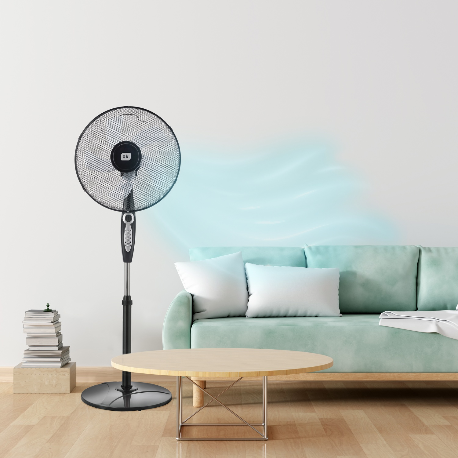 Un ventilatore da terra nero soffia un flusso d'aria blu verso un divano verde menta.