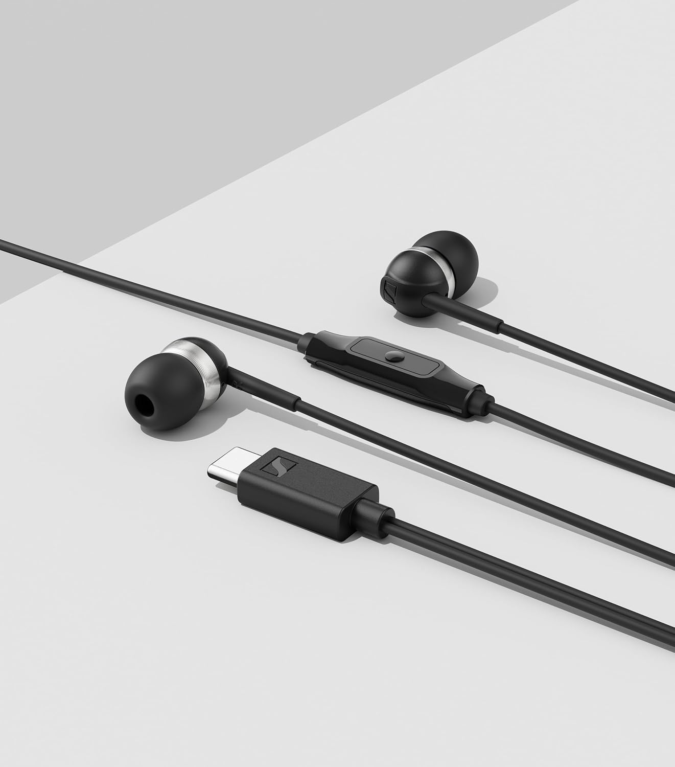 Schwarze In-Ear-Kopfhörer mit USB-C-Anschluss und Fernbedienung auf grauem Hintergrund.