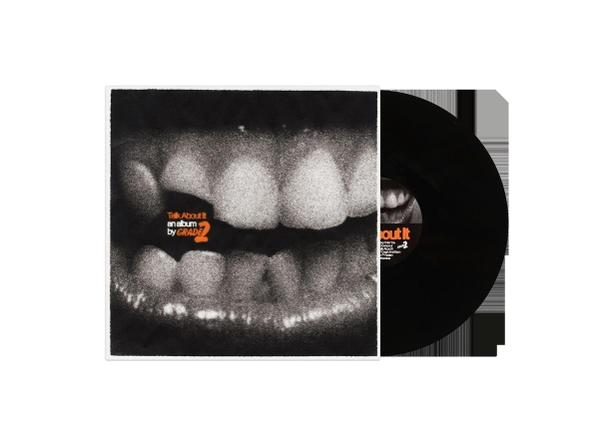 Schwarze Schallplatte mit Albumcover Nahaufnahme von Zähnen.
