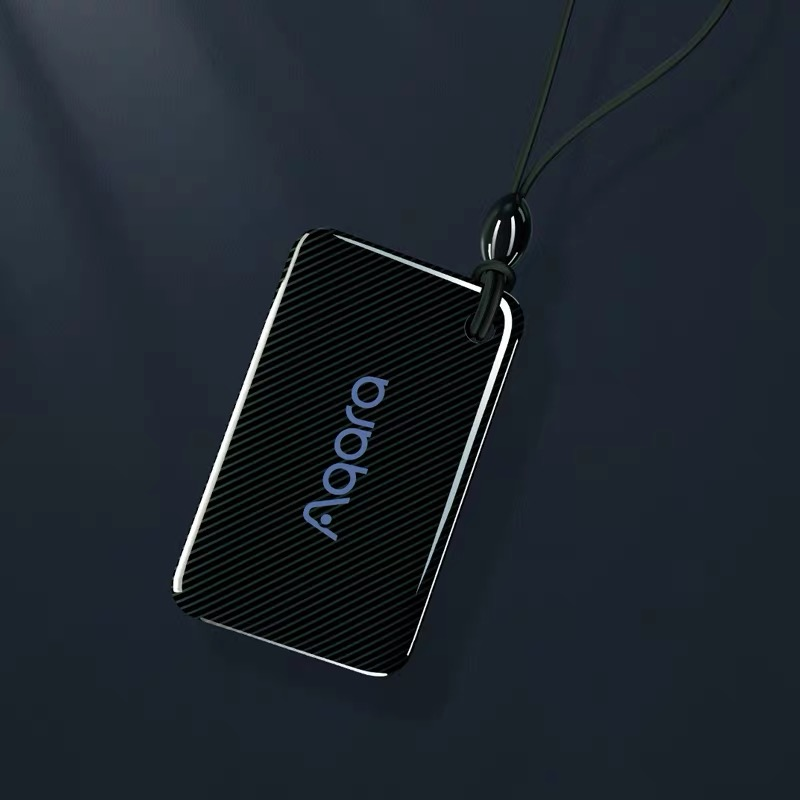 Schwarzer Anhänger mit Aqara-Logo und Lanyard auf dunklem Hintergrund.