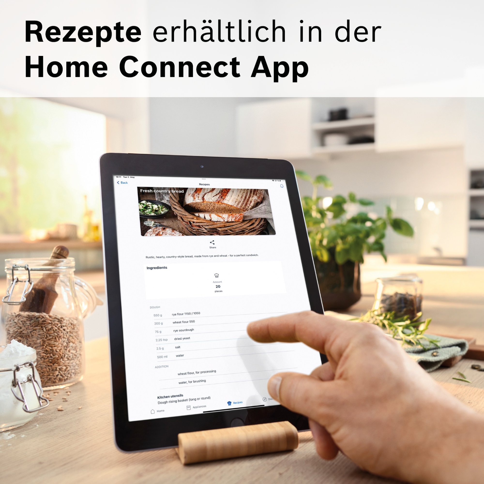 Ein Tablet zeigt ein Brotrezept mit Zutaten und eine Hand tippt auf den Bildschirm.