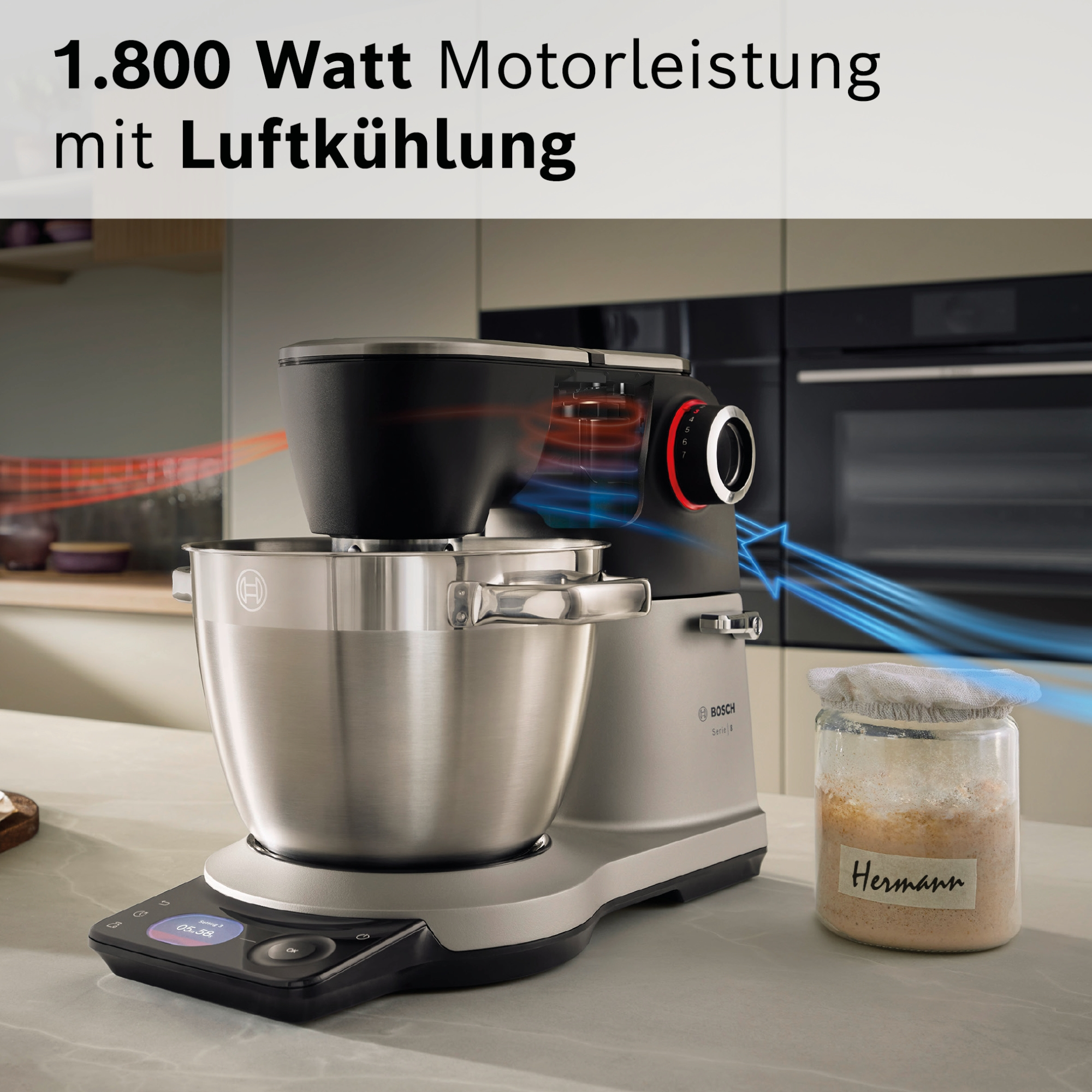 Ein silberner Küchenmixer mit schwarzem Aufsatz, Luftstromlinien werden angezeigt.