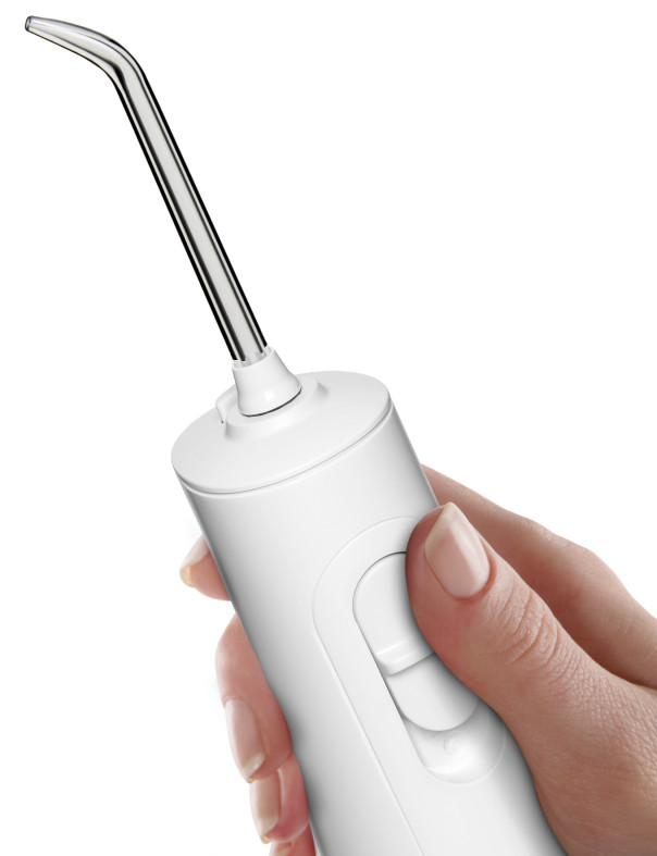 Dłoń trzyma białą irygator doustny z cienką, zakrzywioną metalową dyszą.