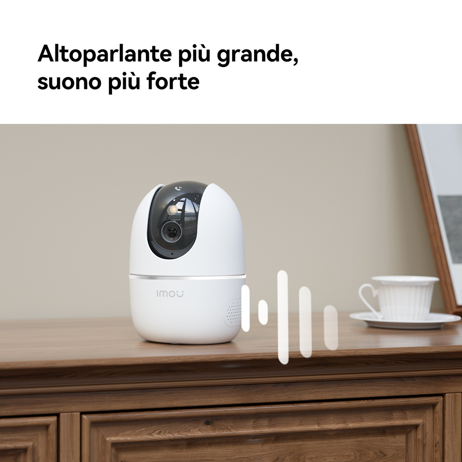 Un altoparlante di sicurezza bianco siede su una cassettiera di legno con una tazza.