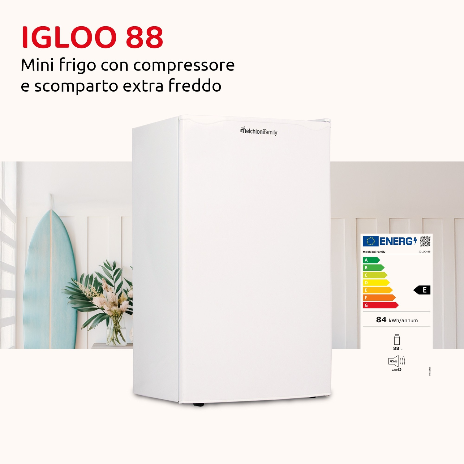 Un mini frigo bianco Melchioni Family con tavola da surf e fiori sullo sfondo.