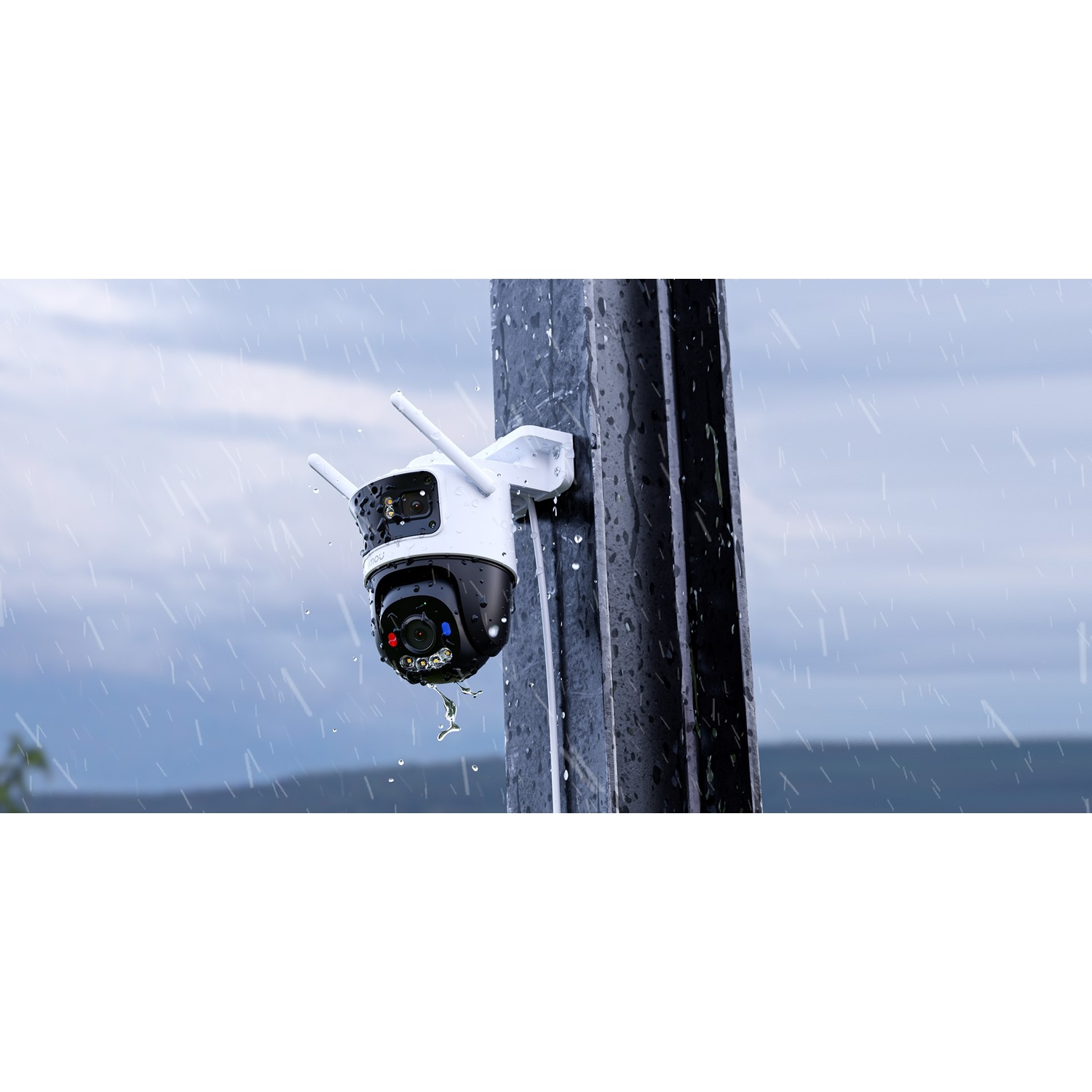 Una telecamera di sicurezza appesa a un palo sotto la pioggia.