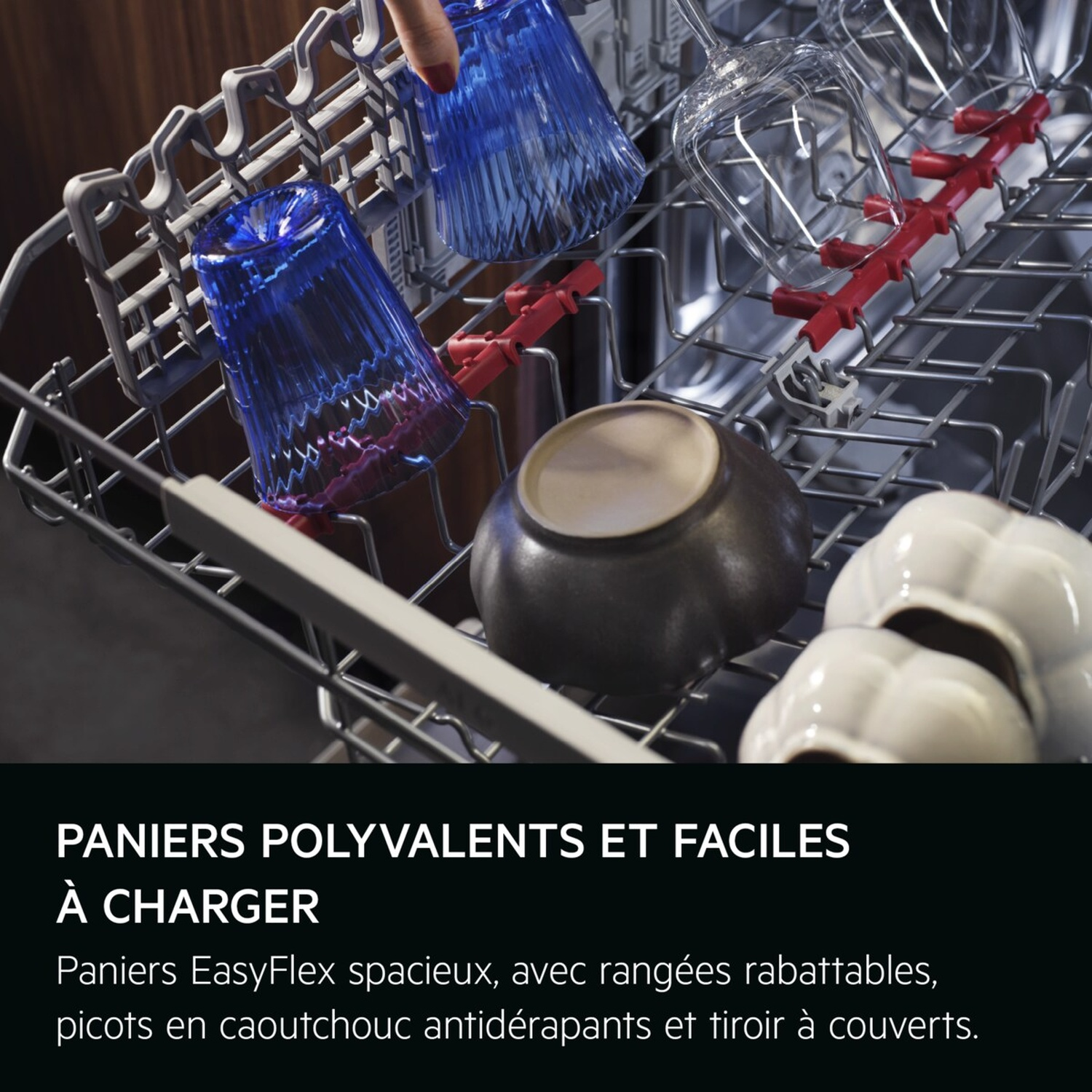 Panier de lave-vaisselle avec verres bleus, verres à pied, bols et bols en céramique blancs.