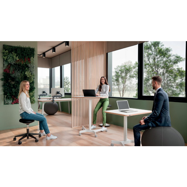 Menschen arbeiten in einem modernen Büro mit Pflanzenwand und großen Fenstern.