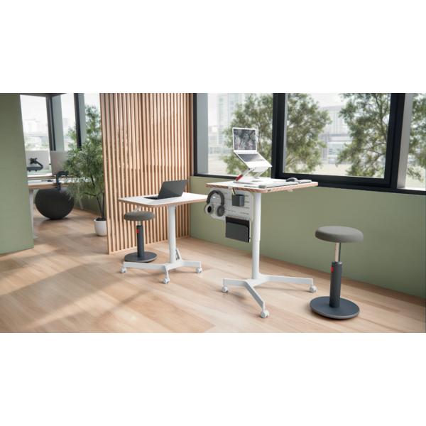 Zwei höhenverstellbare Schreibtische mit Laptops, Kopfhörern und Hocker in einem modernen Büro.