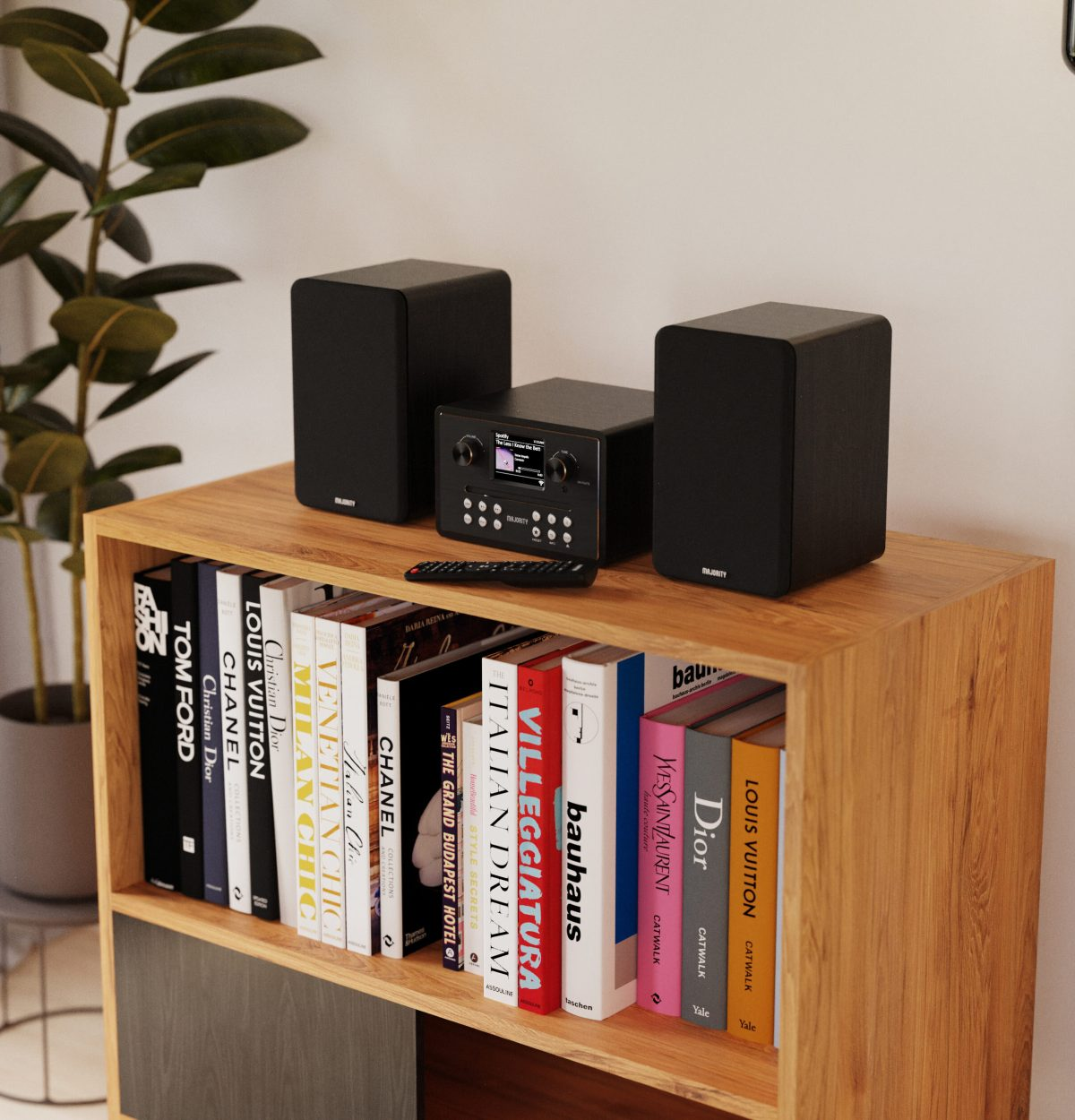 Un sistema stereo nero si trova su uno scaffale di legno accanto a libri.