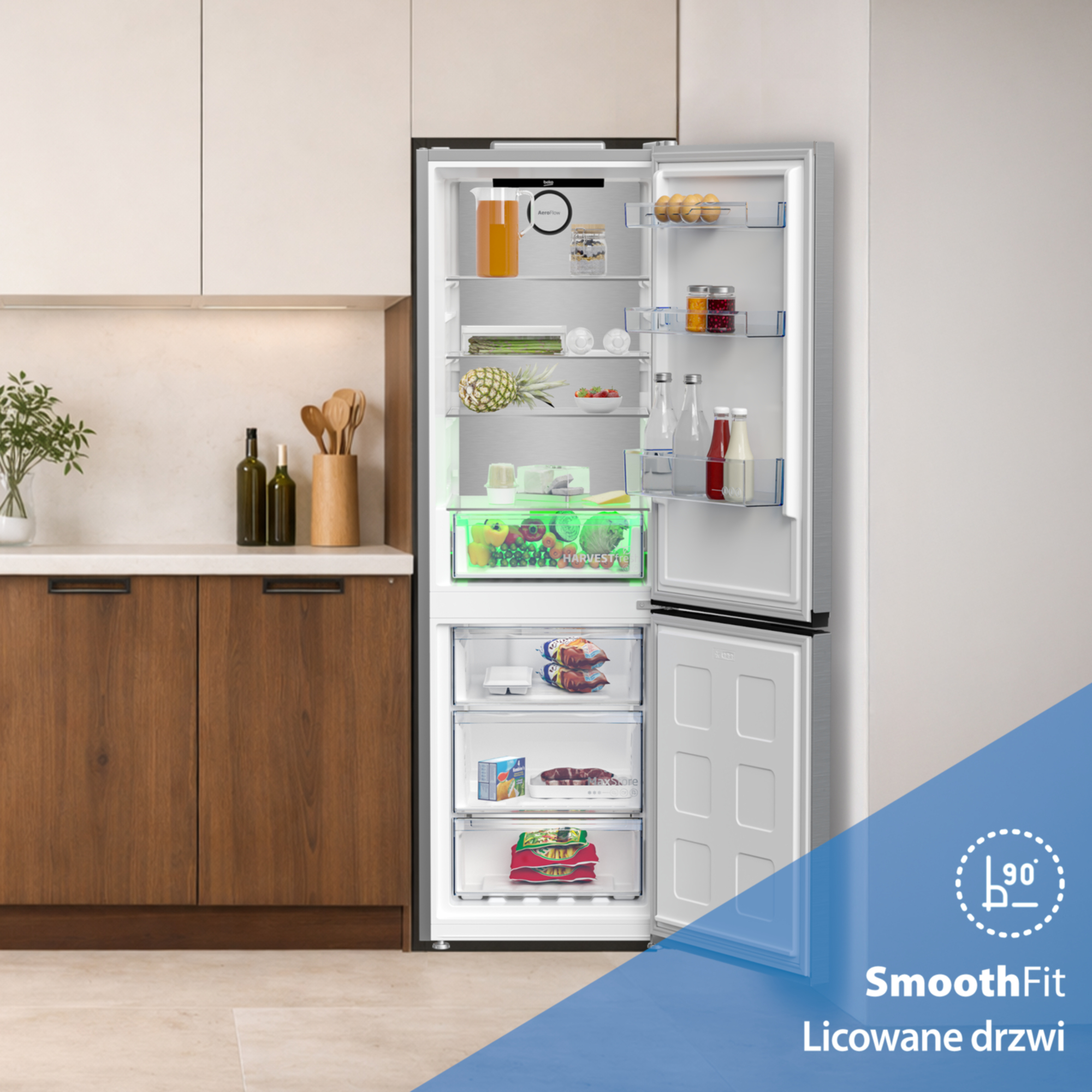 Otwarta lodówka wypełniona jedzeniem i szufladami. Na blacie butelki i drewniane łyżki.