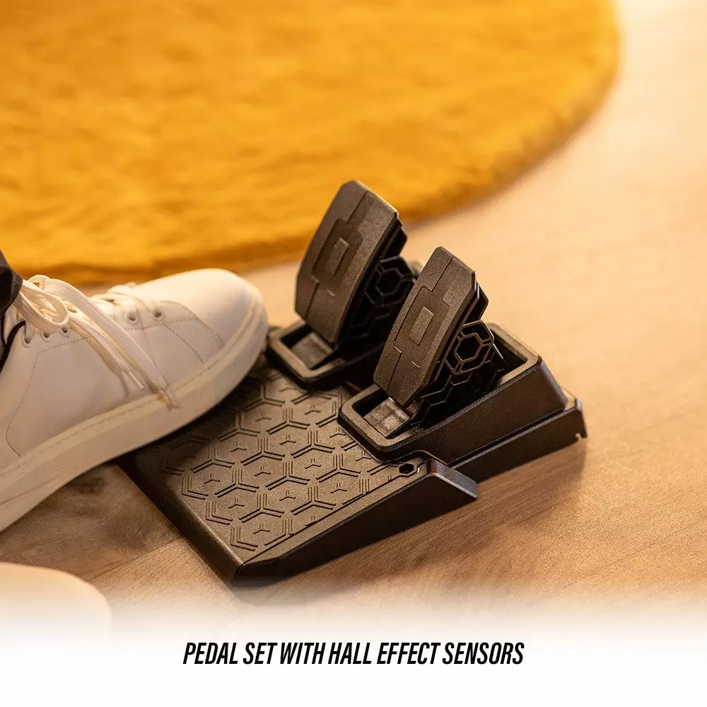 Schwarzes Pedalset mit Hall-Effekt-Sensoren, daneben ein weißer Schuh.
