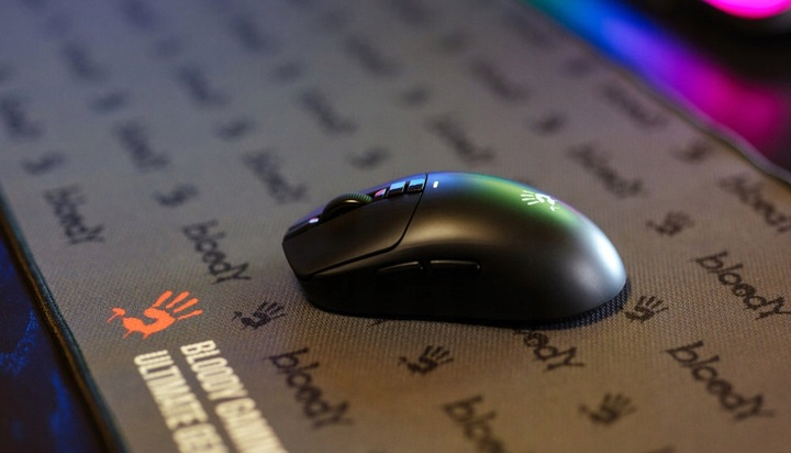 Czarna mysz na podkładce Bloody z pomarańczowym symbolem dłoni.