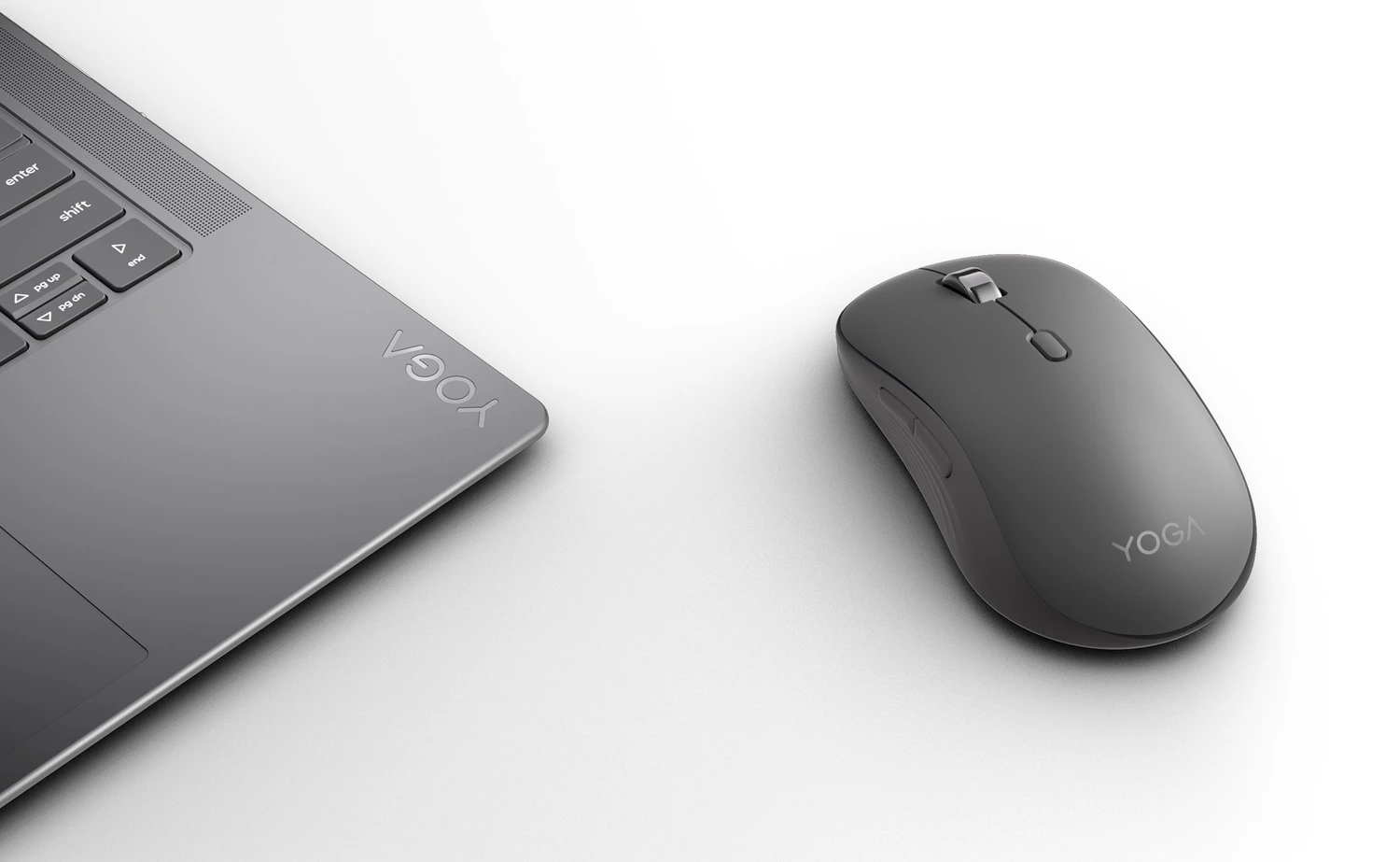 Szary laptop Lenovo Yoga i pasująca mysz na białej powierzchni.