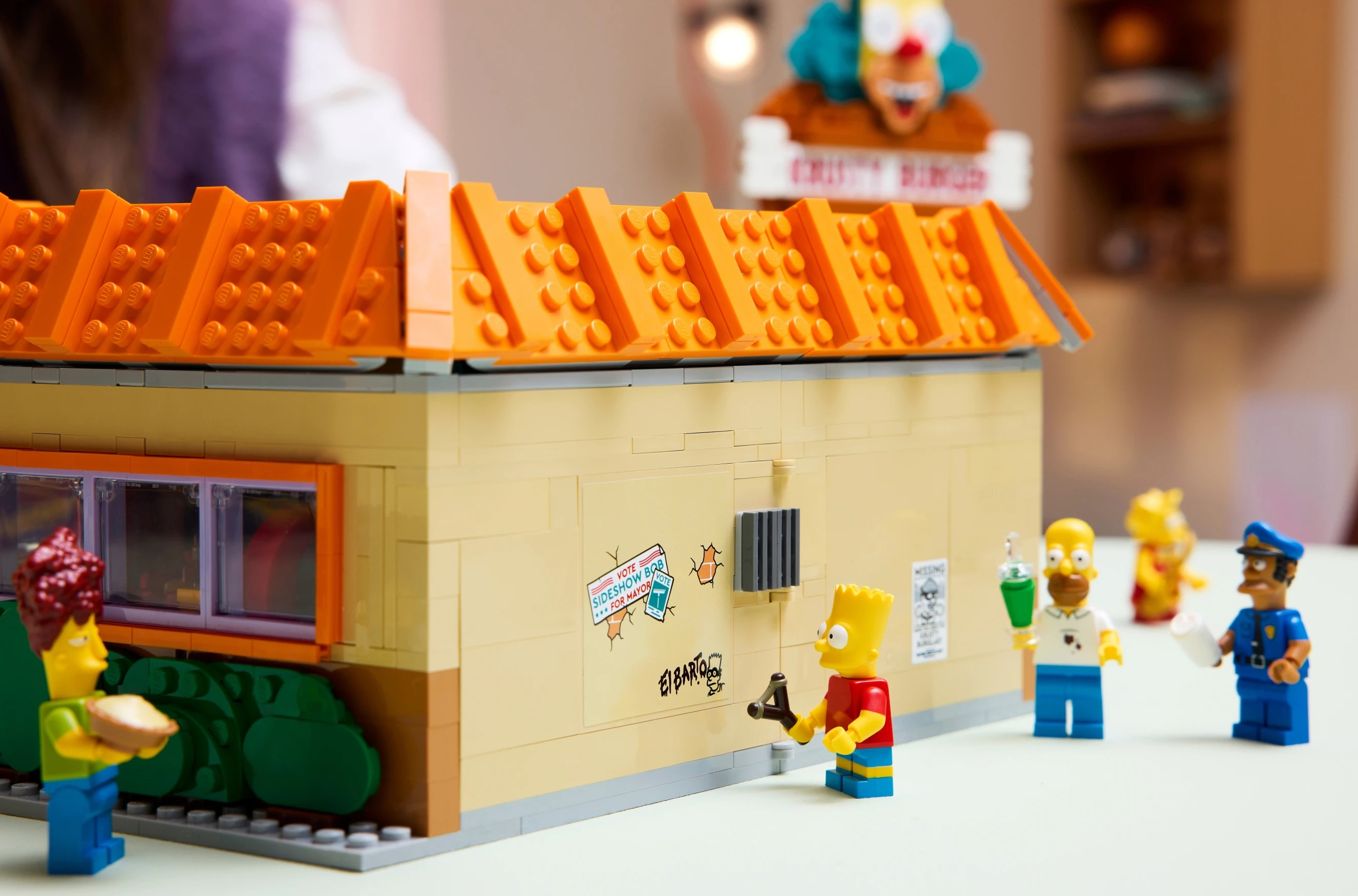 Scena LEGO Simpsonów z Bartem, Homerem, policjantem i Krustym w tle.