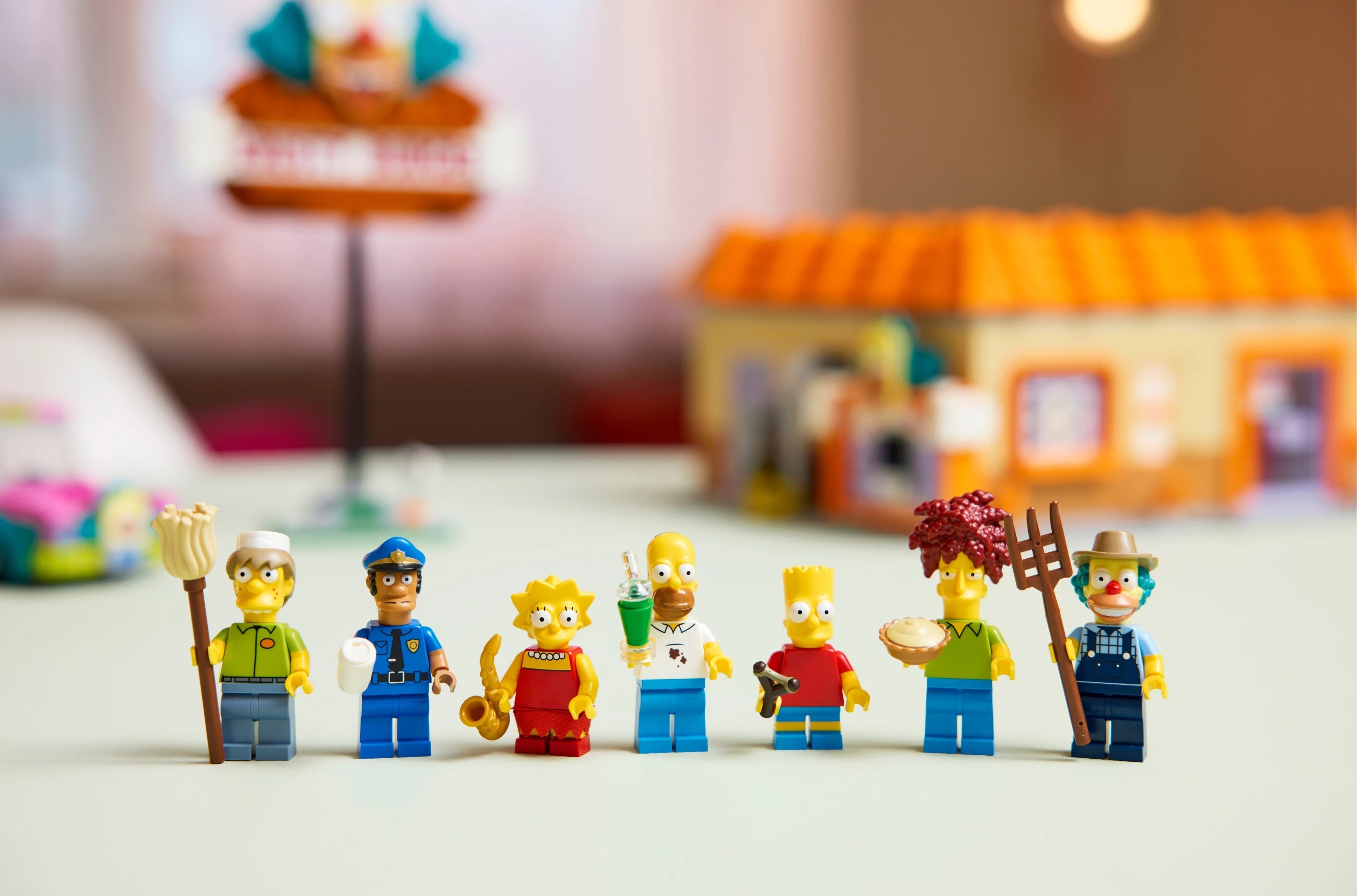 Figurki Lego postaci z Simpsonów: Willie, policjant, Lisa, Homer, Bart, Bob, Krusty.