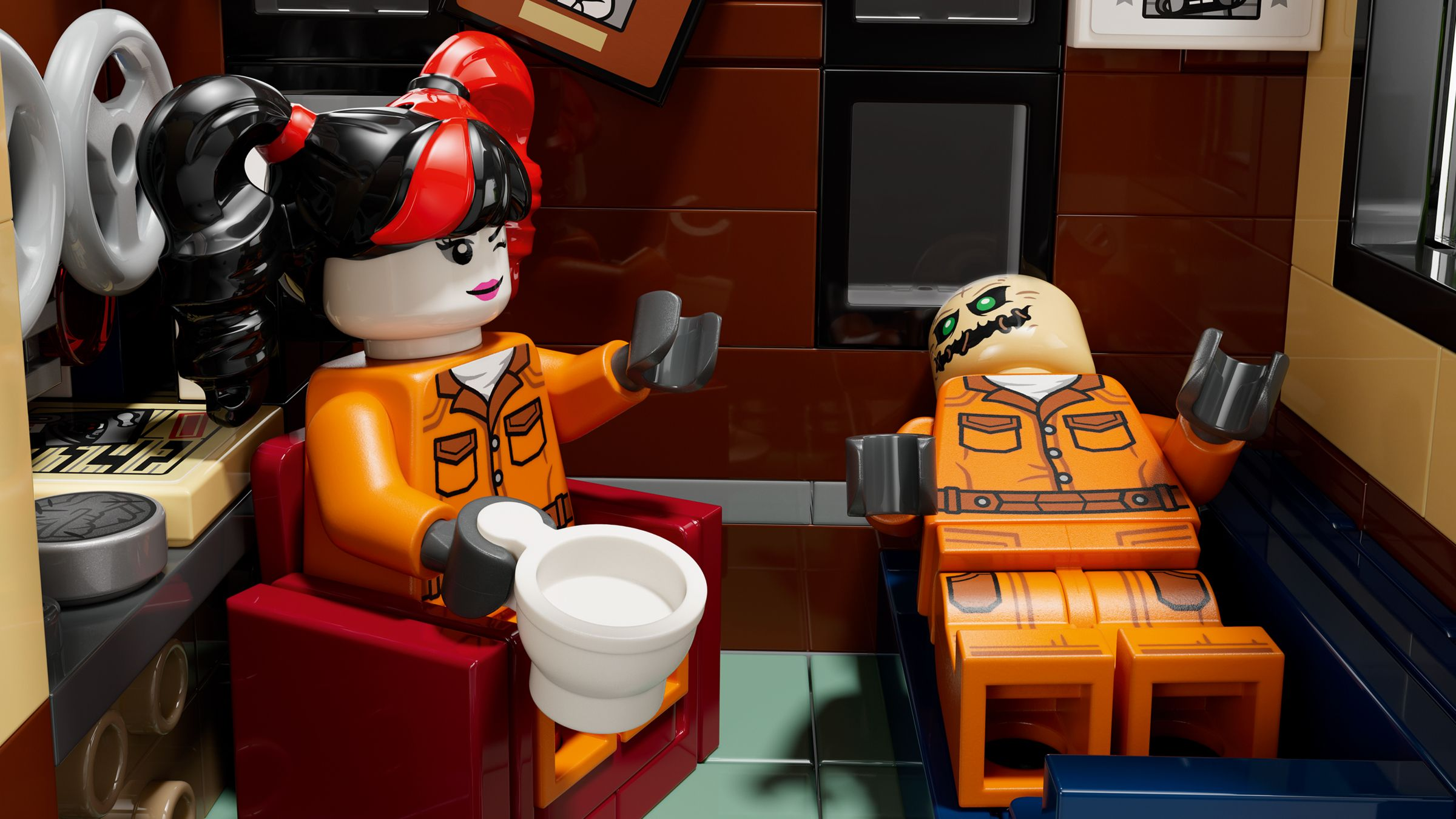 Dwie figurki Lego w pomarańczowych strojach więziennych. Jedna trzyma miskę, druga kubek.