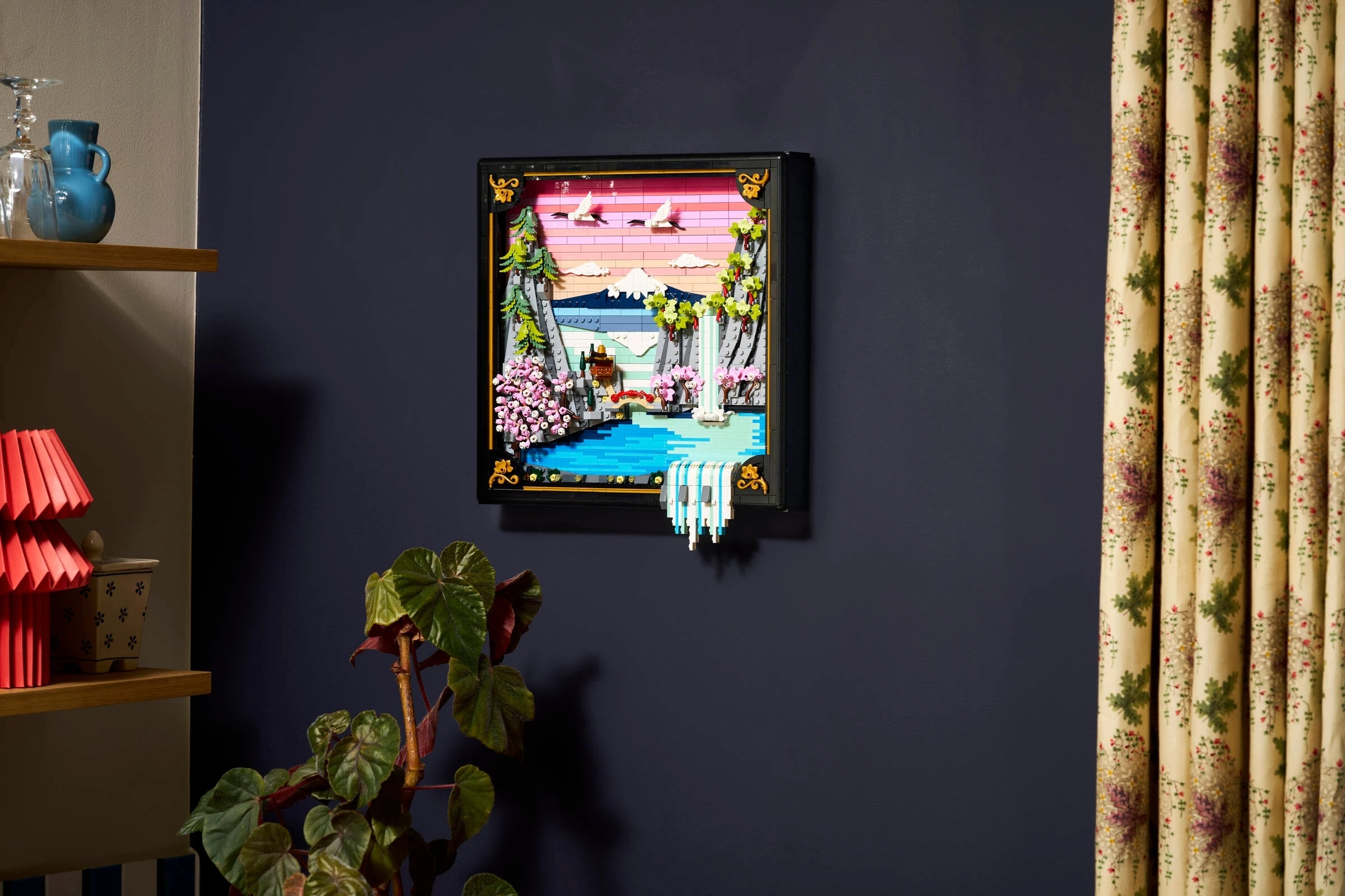 Diorama Lego z górą, wodospadem, stawem i latającymi żurawiami.
