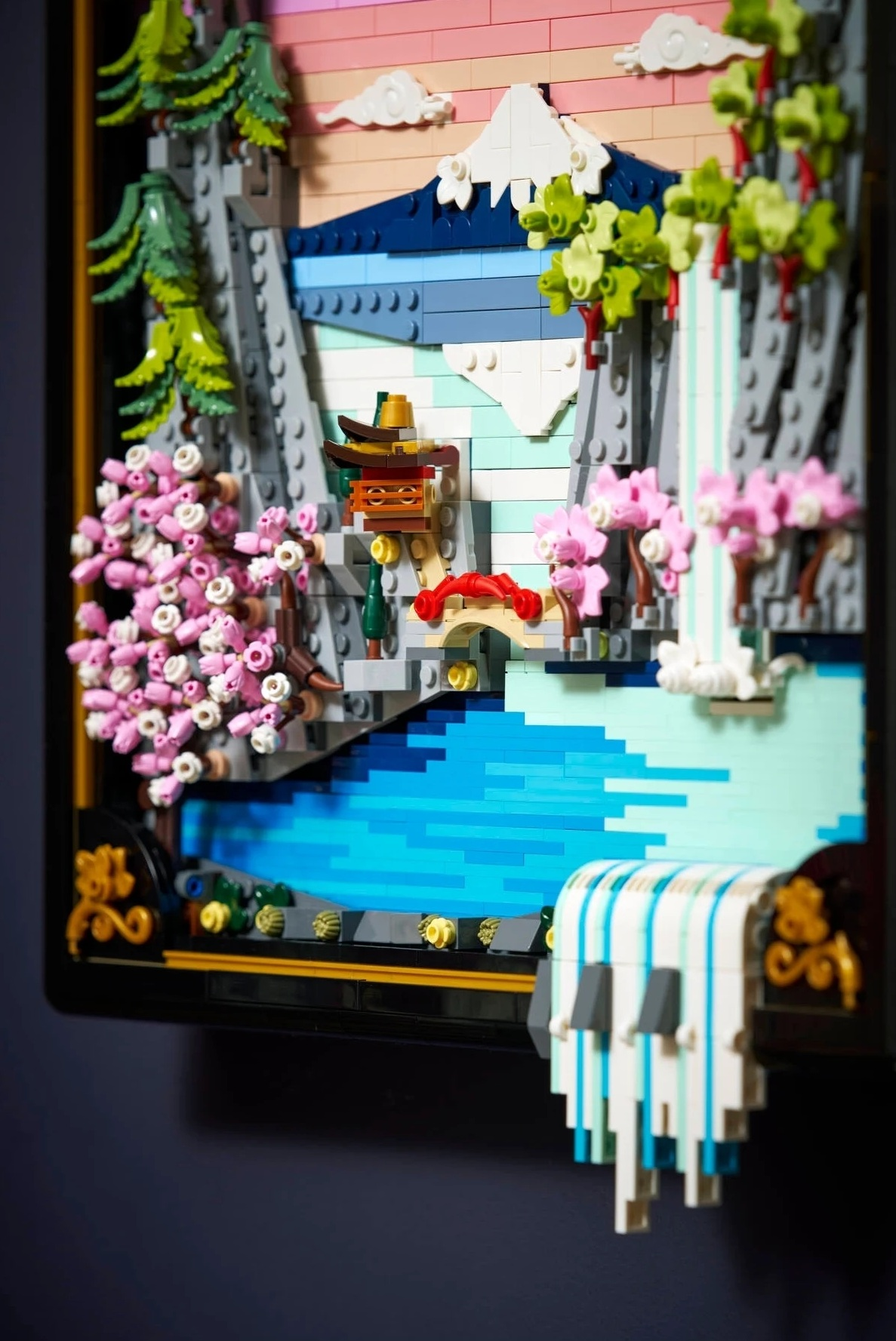Scena Lego z górą, wodospadem, kwiatami i pagodą.