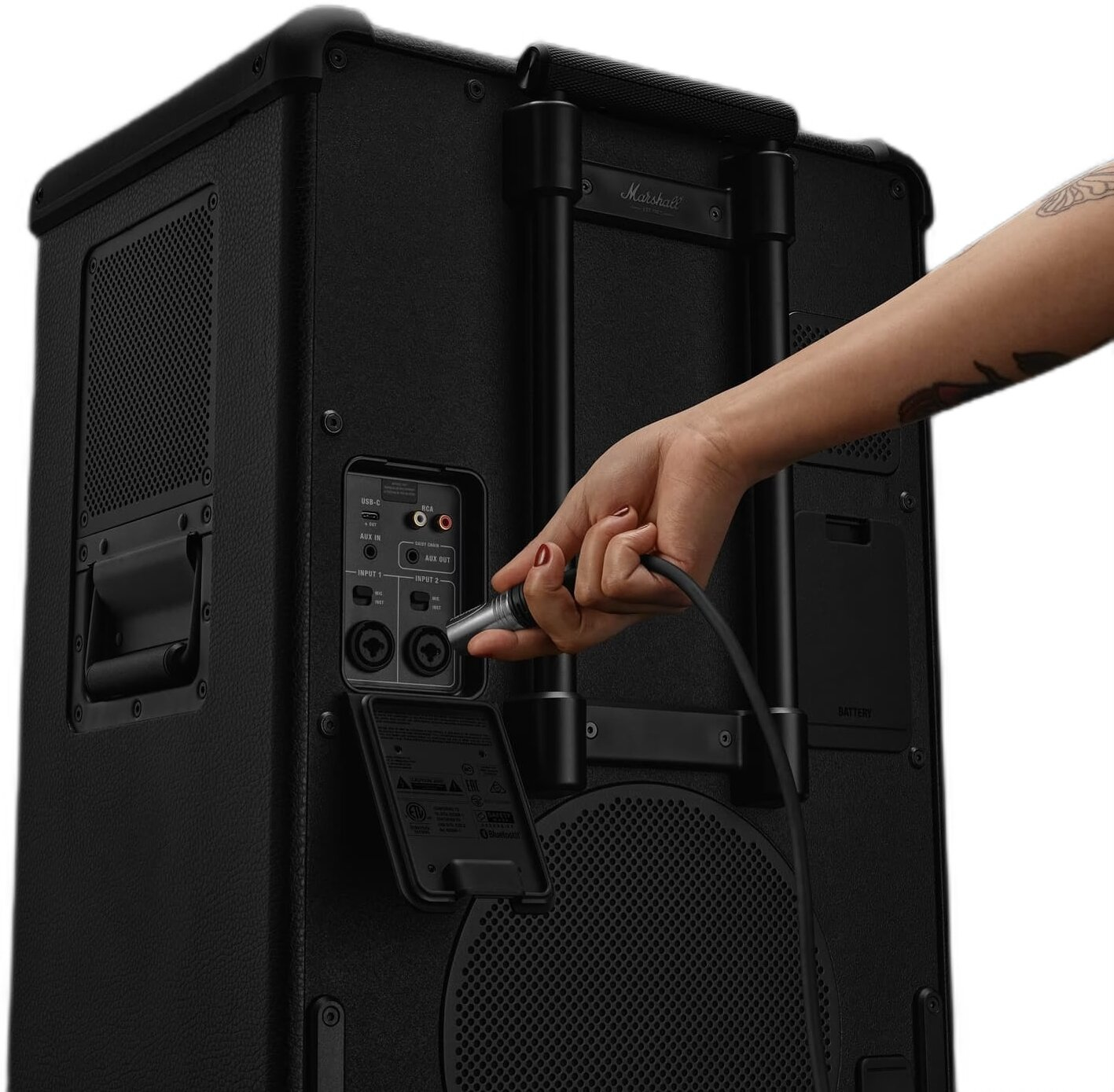 Ręka podłącza kabel do wejścia głośnika Marshall.