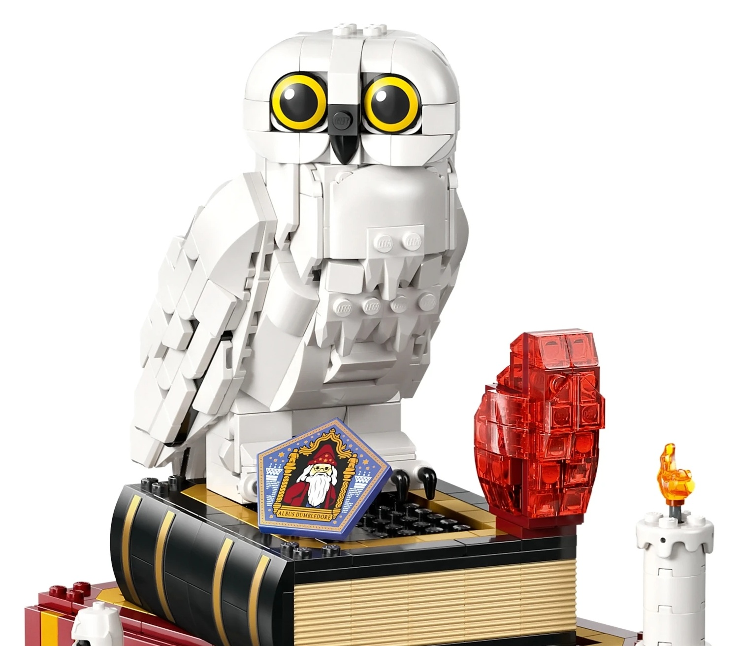 Biała śnieżna sowa Lego siedzi na książce z naklejką Albus Dumbledore.