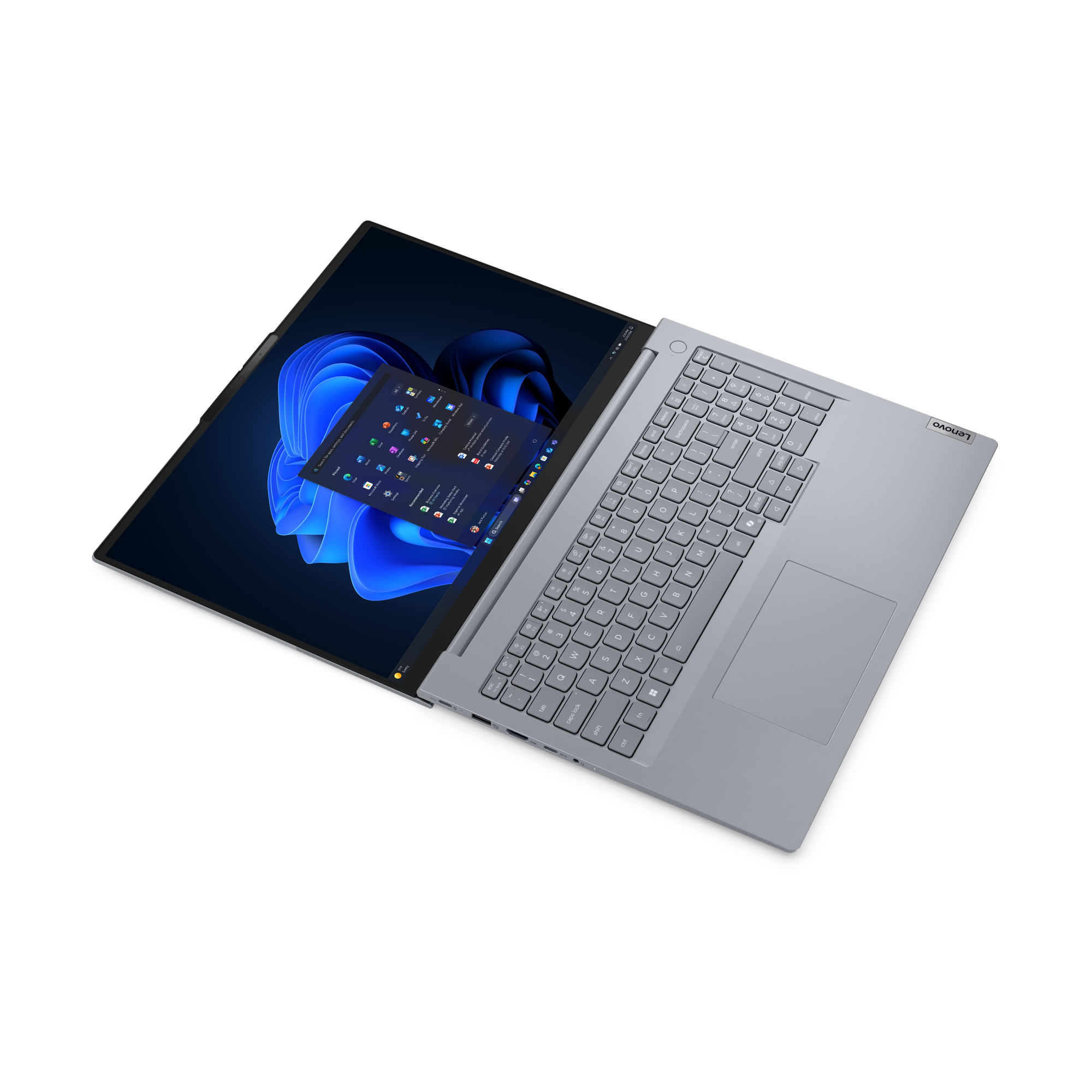 Ein hellgraues Lenovo-Laptop ist geöffnet. Der Bildschirm zeigt Windows 11 mit App-Symbolen.