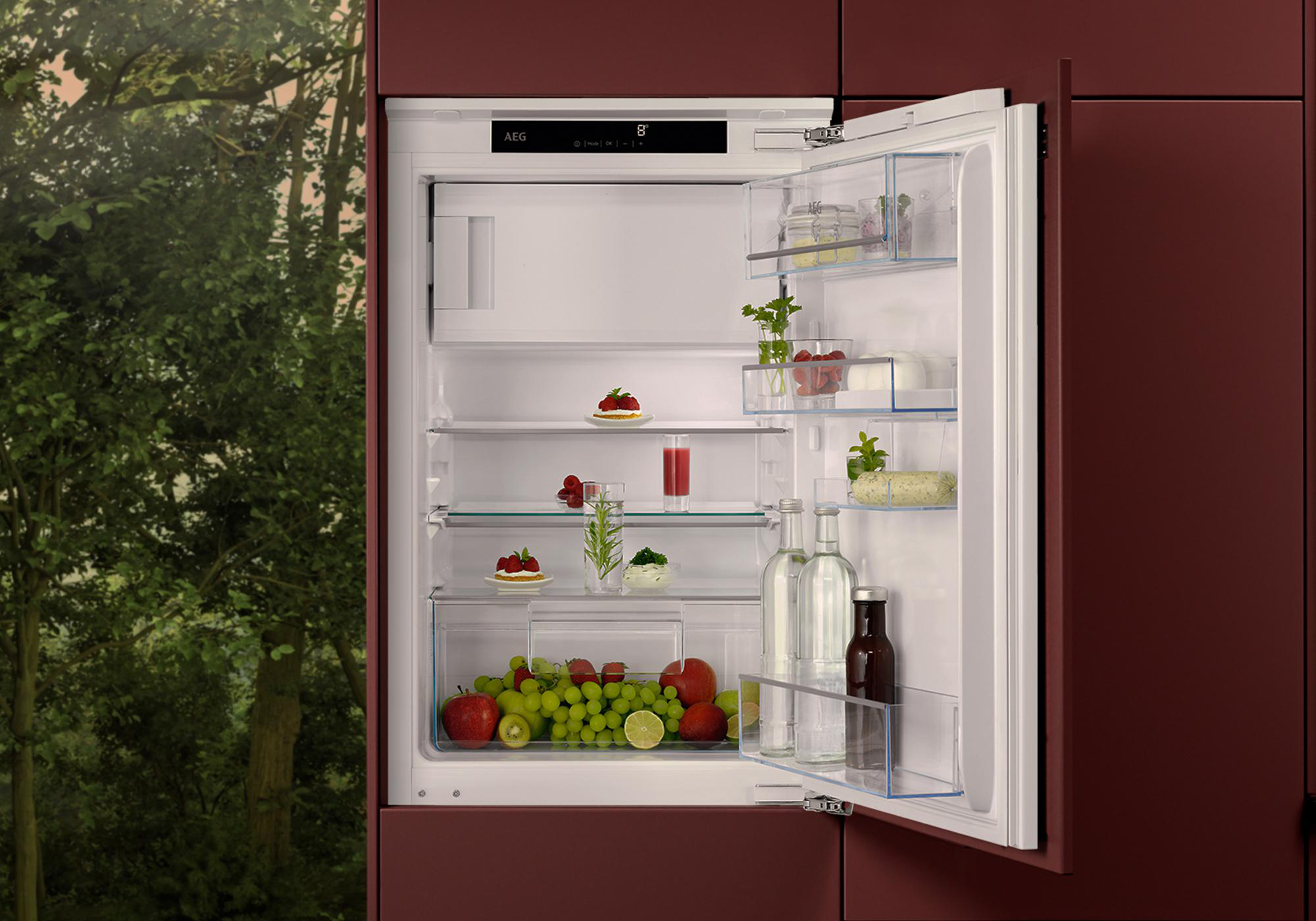 Ein offener Kühlschrank mit Obst, Gemüse und Getränken.